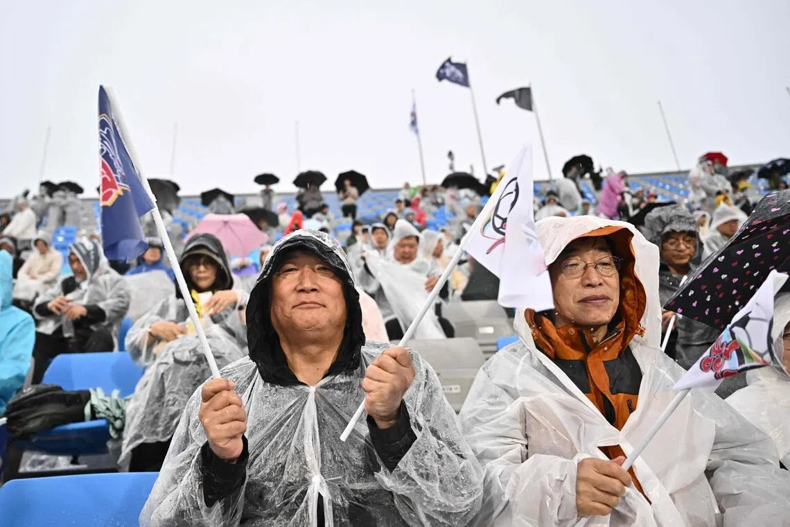 由来自韩国200多个民间团体、约3000人组成的拉拉队，在比赛期间身穿雨衣为两队加油助威。也有韩国球迷赛前说，会更支持朝鲜队，毕竟她们是远道而来。（法新社）