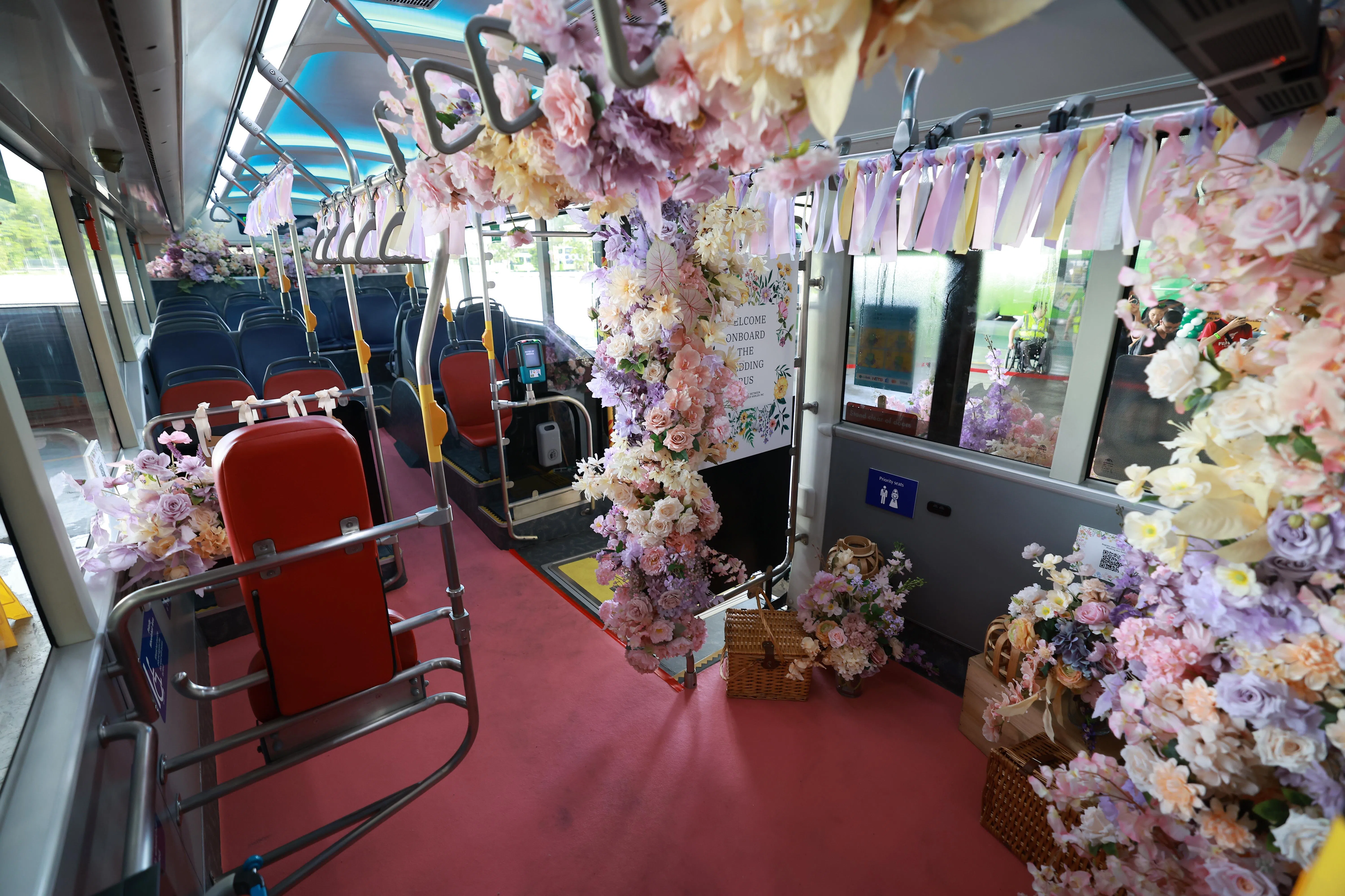 婚礼巴士内部装饰着粉色花卉、丝带、红地毯等婚礼上常见的布置。（新明日报）