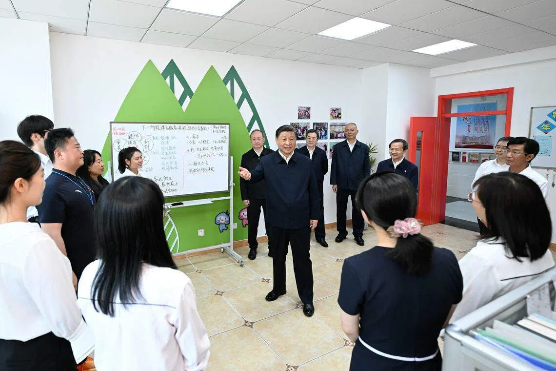 中国国家主席习近平来到北京育英学校看望慰问师生，向全国广大少年儿童祝贺“六一”国际儿童节快乐。图为习近平在教师办公室同教师们交流。（新华社）