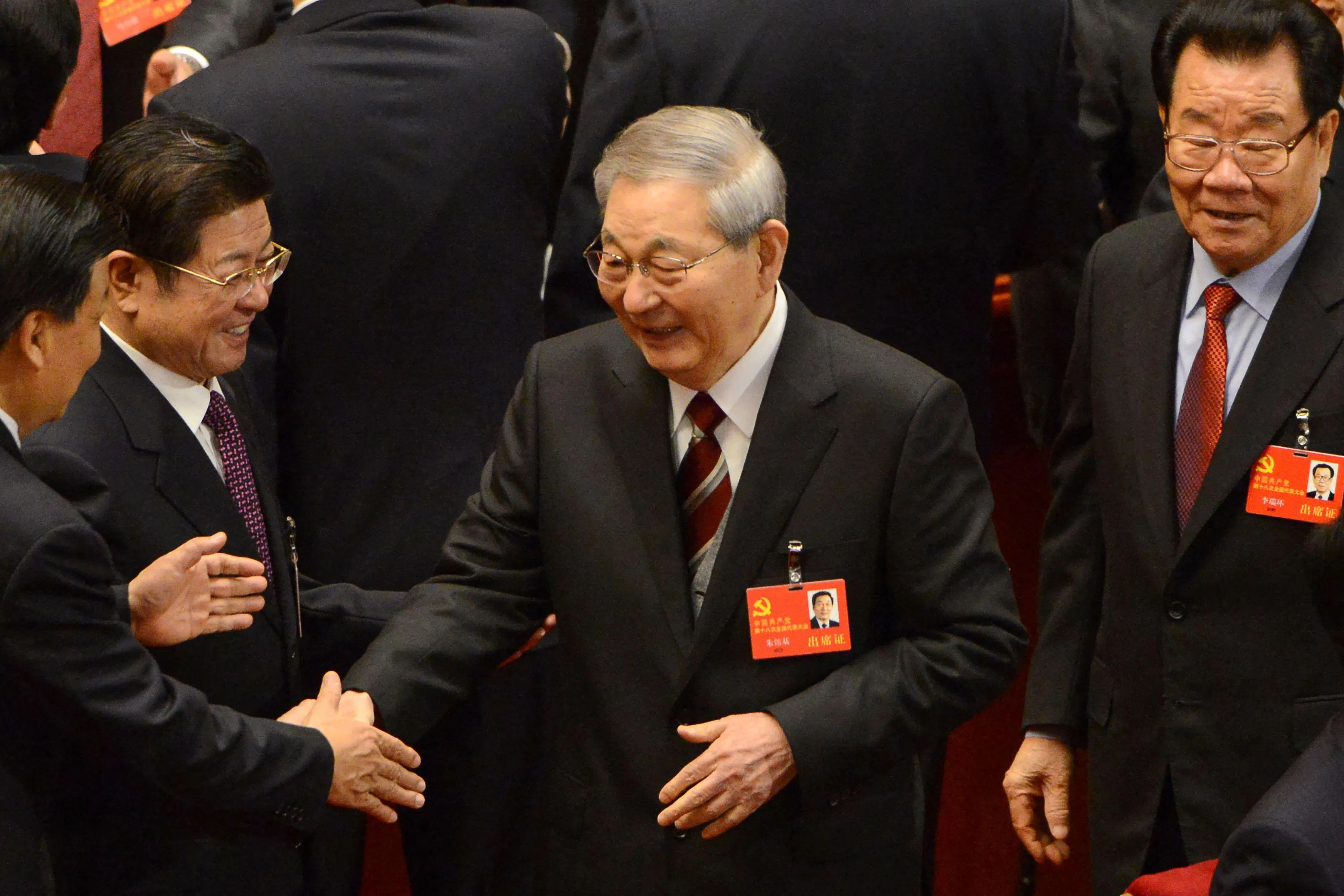 2012年11月8日，朱镕基（中）在人民大会堂出席中共十八大开幕式时，与一名代表握手。（法新社）