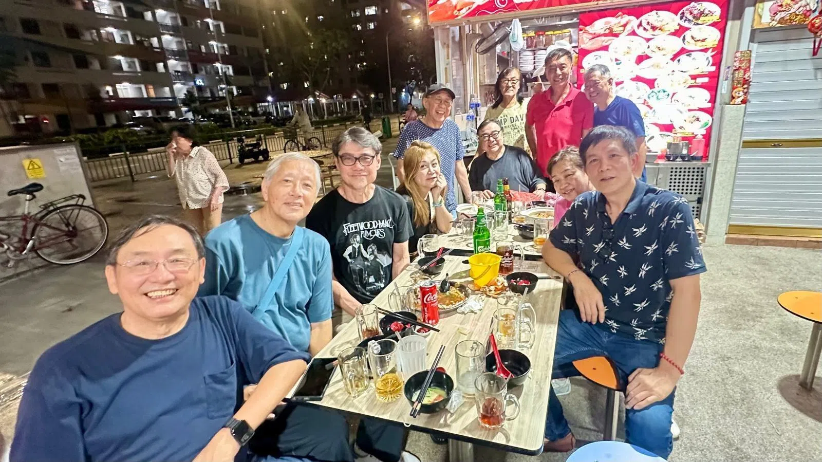 杨莉冰（左四）和黄奕良（右四）是多年好友，她之前和林益盛（右一）等圈中好友到黄奕良的摊位捧场。（互联网）