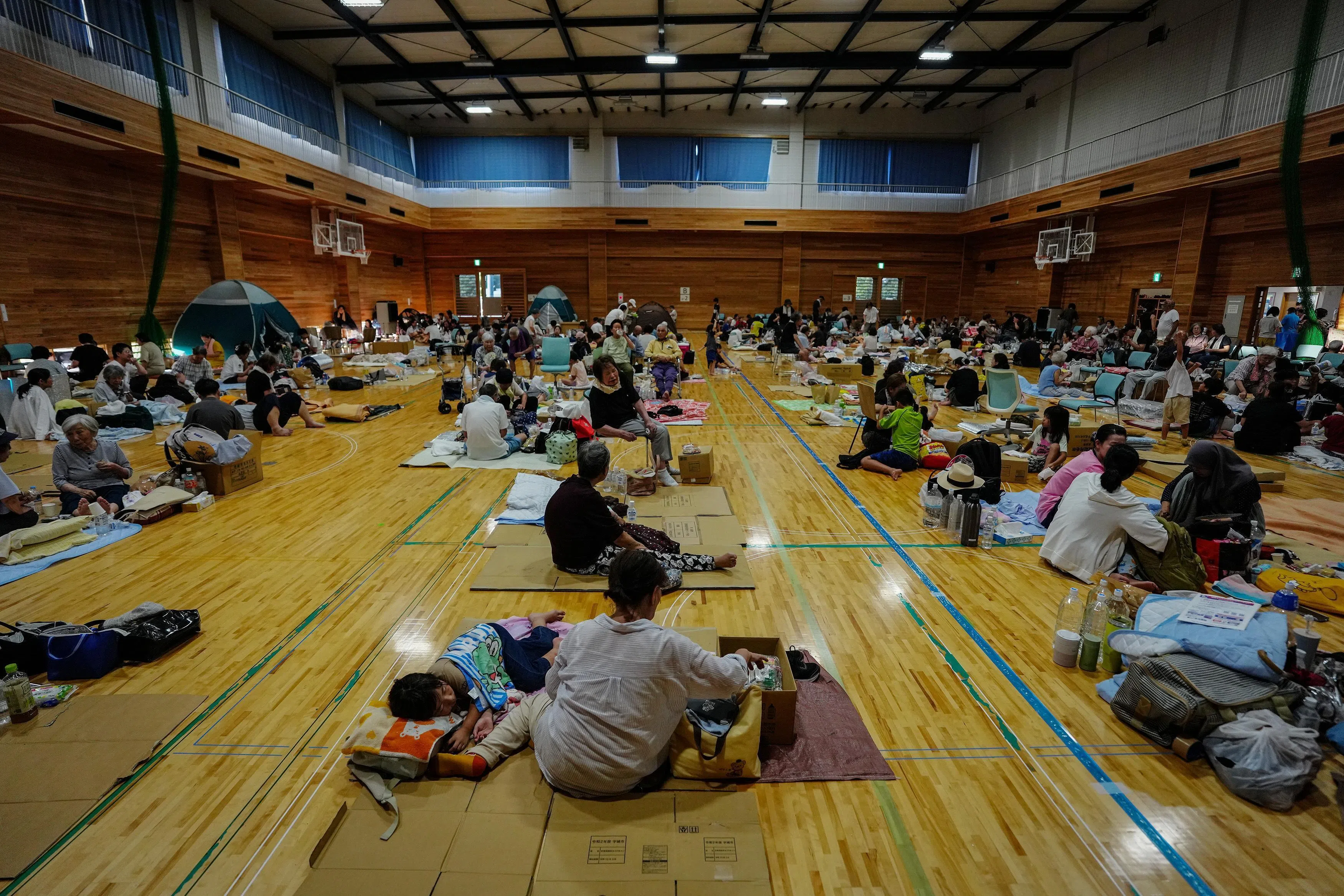 日本熊本县周二的大地震造成广泛破坏和大范围停电断水，许多居民被迫到避难所避难。（新华社）