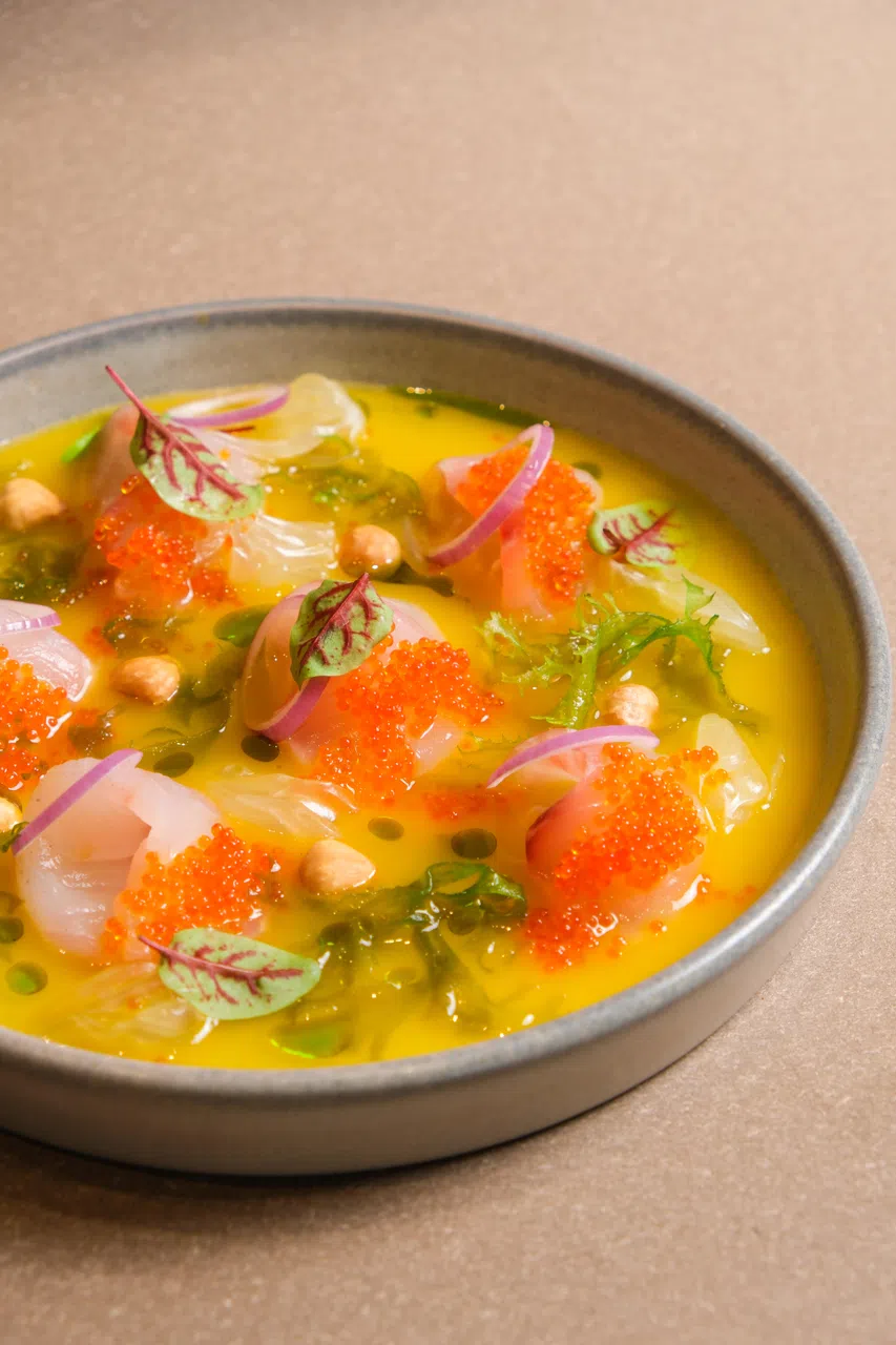 油甘鱼刺身佐秘鲁黄辣椒酱（Hamachi Tiradito with Aji Amarillo Dressing）选用鲜嫩油甘鱼切片，融合秘鲁经典黄辣椒酱汁，口感清新爽口，唤醒味蕾。（餐馆提供）