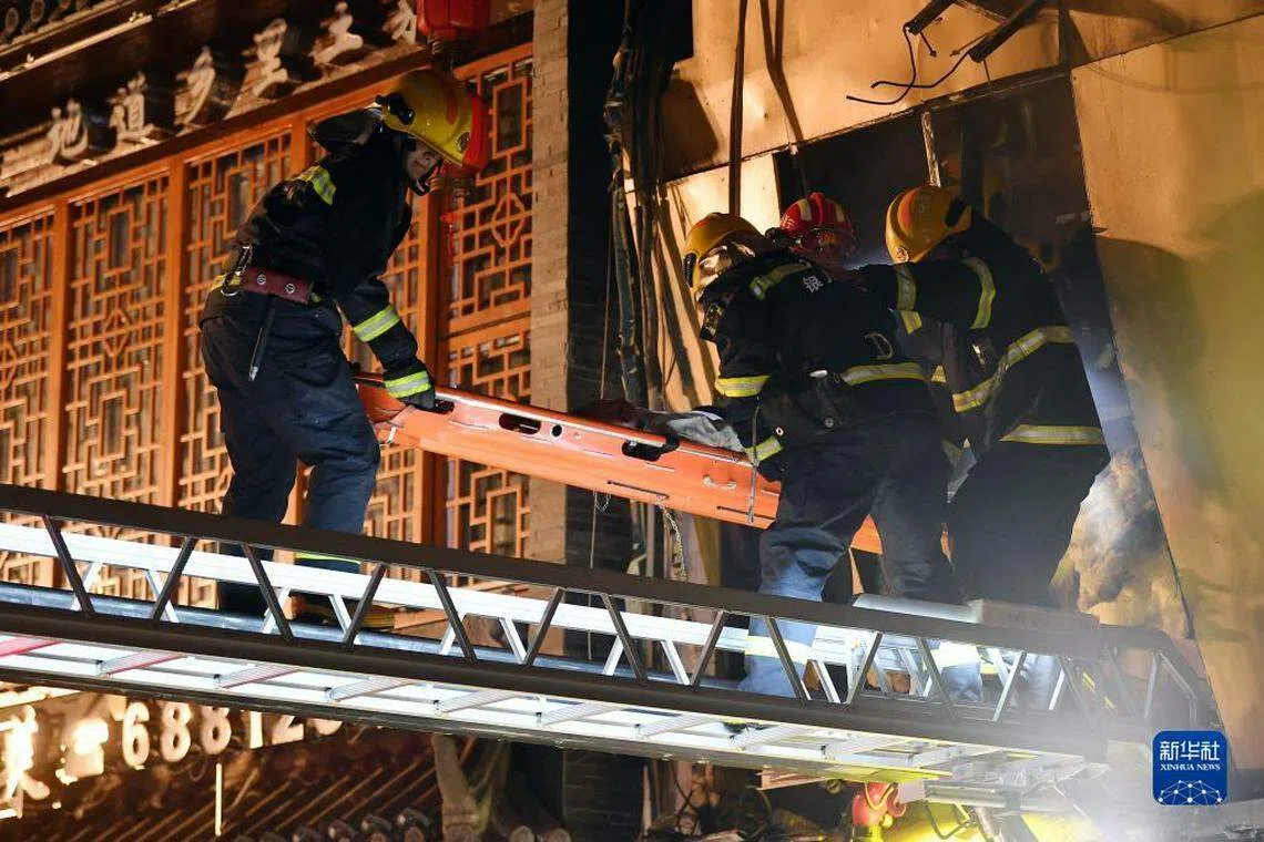消防救援人员将受困人员从爆炸现场救出。（新华社）
