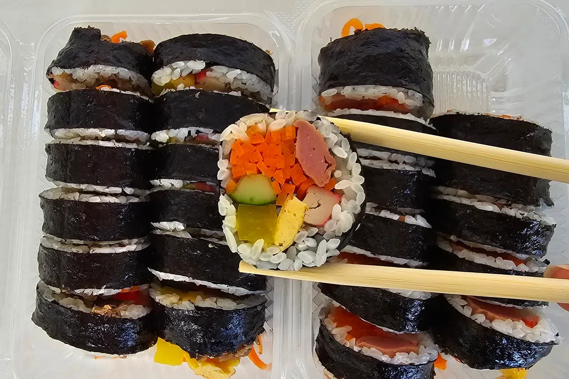 有鸡肉火腿、韩国鱼饼、吞拿鱼和牛肉四种口味的韩式饭卷。（黄亿敏摄）