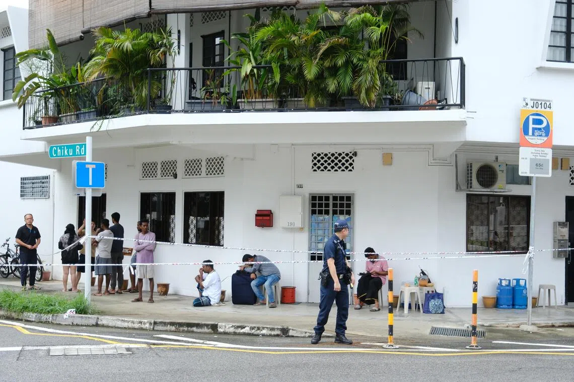 居民和客工聚集在封锁线外，神情疲惫，一些人逃命时还带着行李箱。（曾坤顺摄）