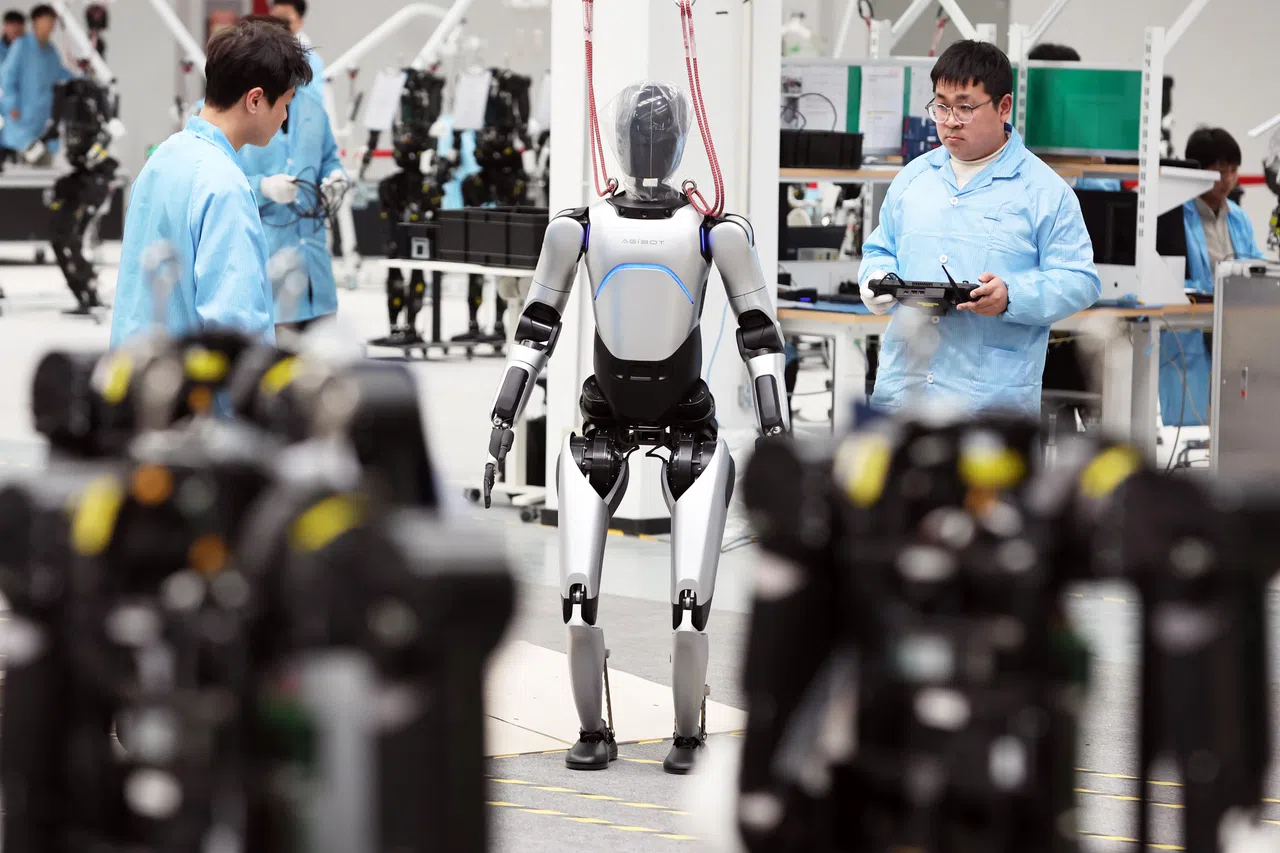 中国的机器人公司正逐步从国际企业手中抢过中国国内市场份额，更将2025年定为人形机器人的量产元年。图为上海首座人形机器人量产工厂智元机器人制造厂的工程师正在测试产品。（中新社）