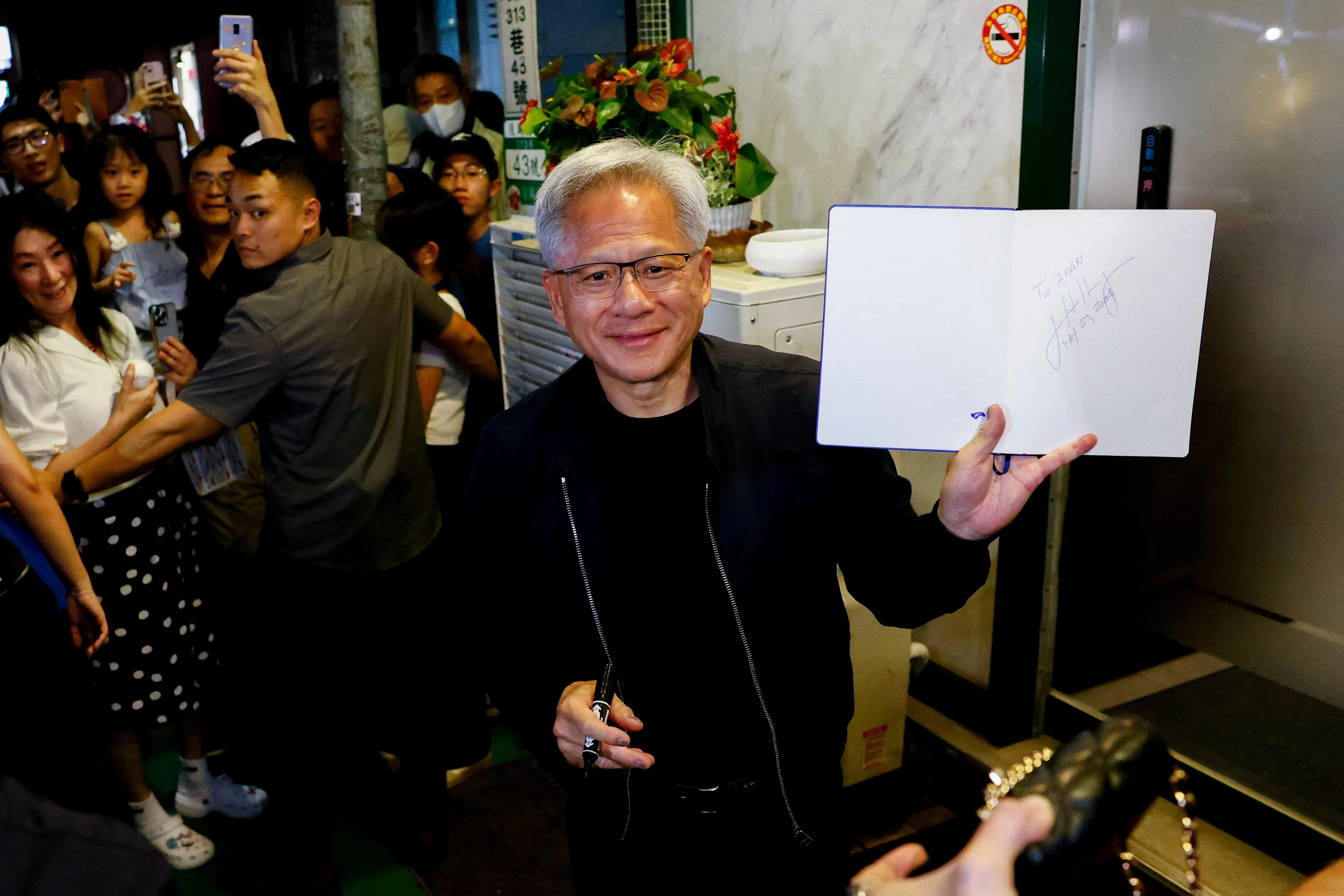 英伟达执行长黄仁勋星期五（5月16日）在台北一家餐厅外与粉丝互动。（路透社）