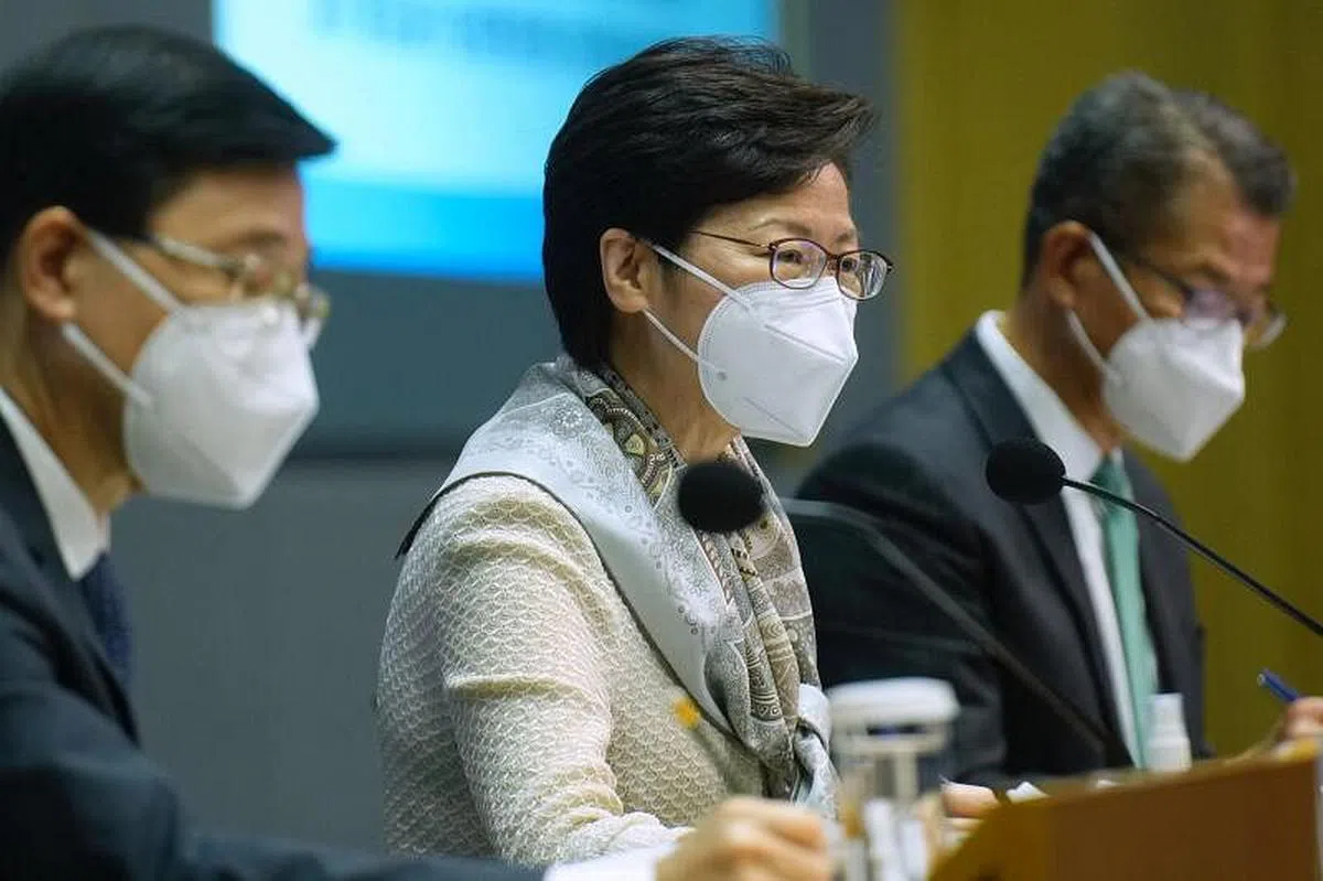 （左起）香港政务司司长李家超、特首林郑月娥和财政司司长陈茂波今年3月21日出席抗疫记者会。（法新社）