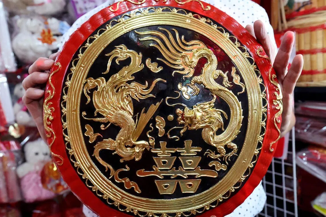 店里的黑色过大礼篮子饰有金色龙凤图案，是特地订做的款式。（梁麒麟摄）