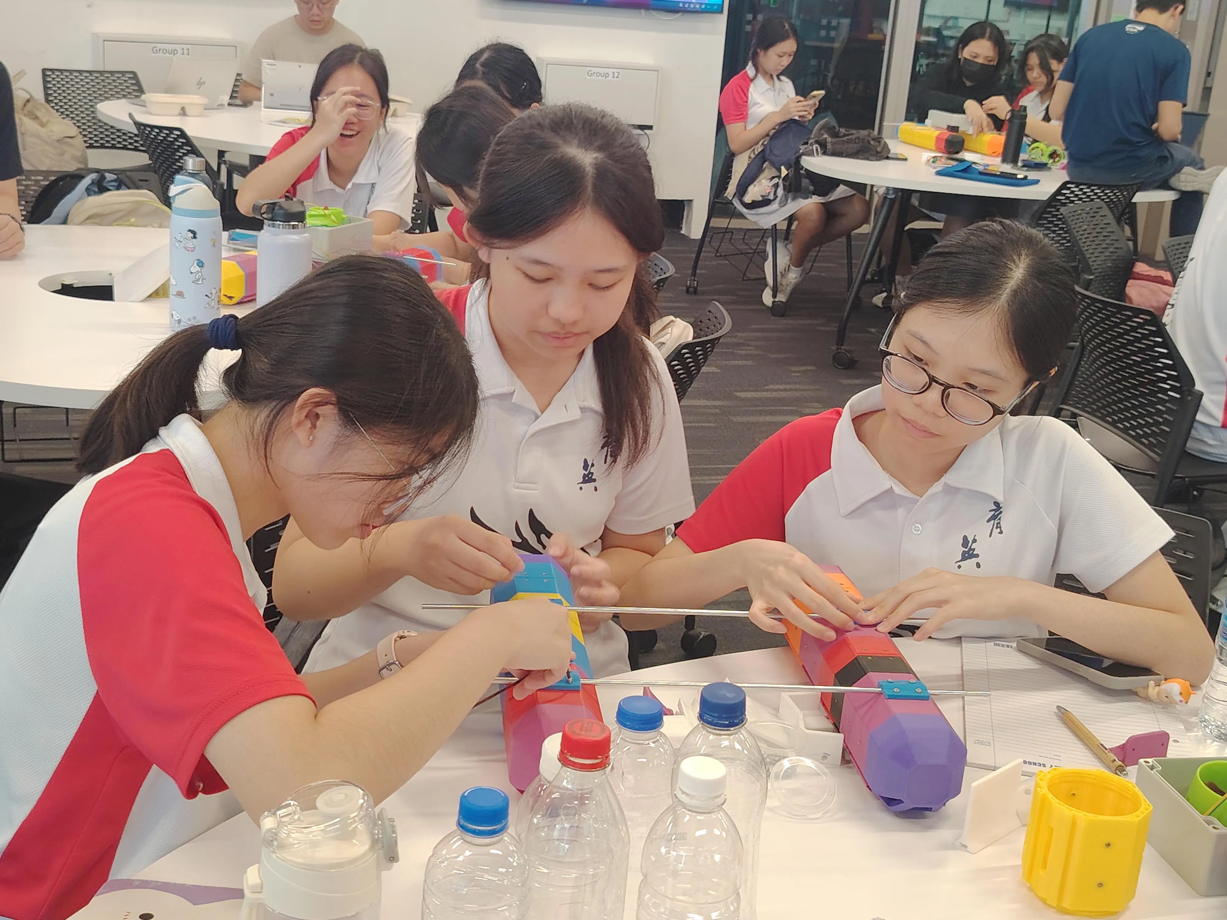 学生合作组装水上机器。（育英中学提供）