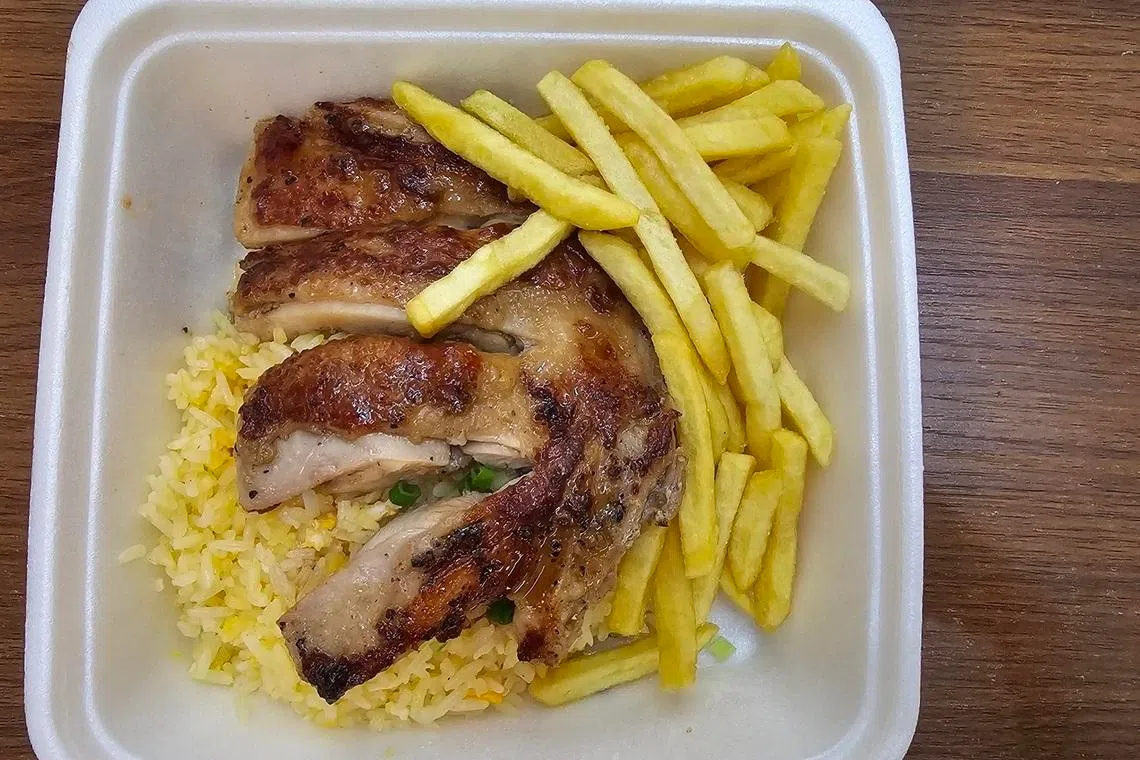 奥斯美食餐馆售卖多种食物，鸡排蛋炒饭配薯条，分量价格合理。（黄亿敏摄）