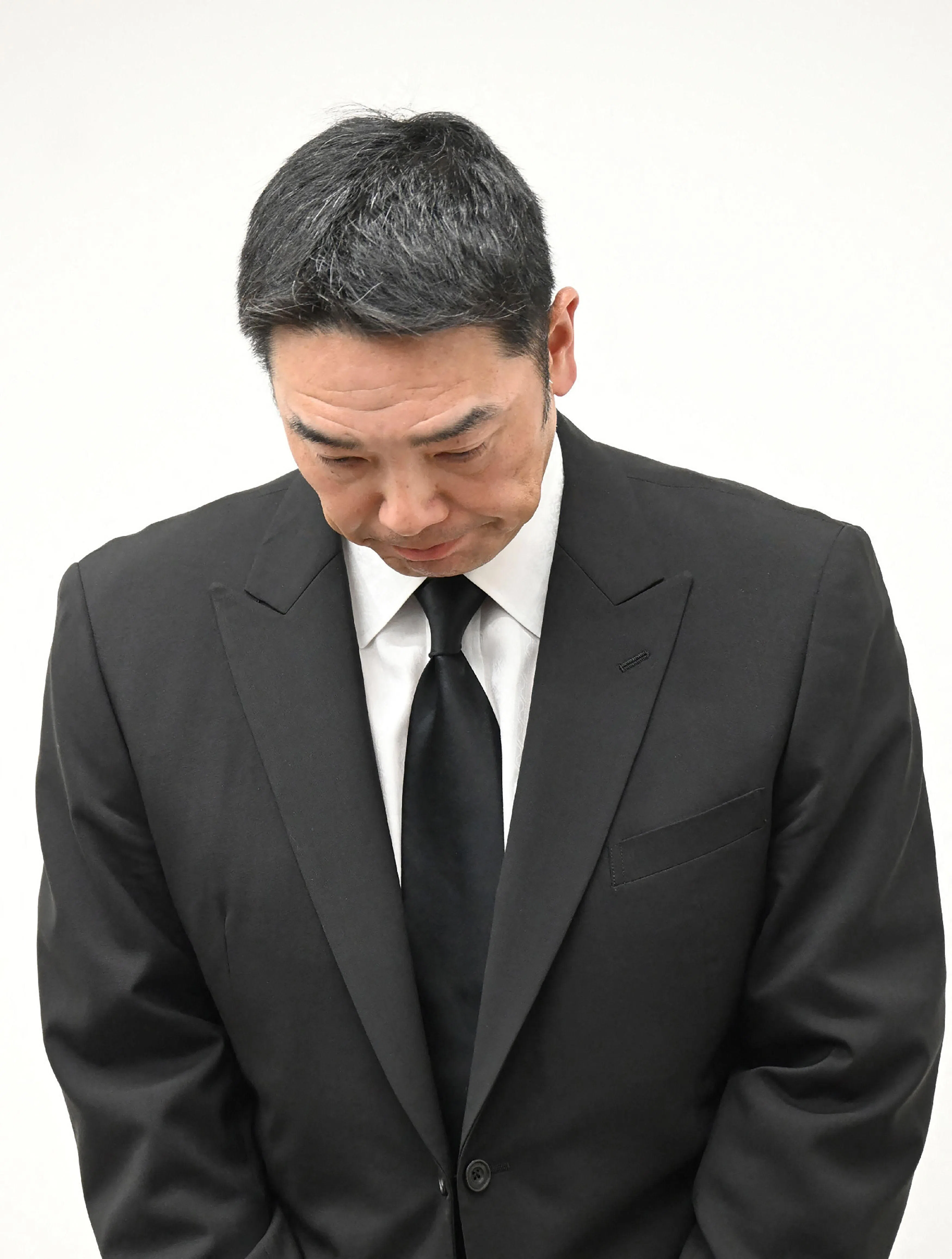 阿部慎之助在宣布辞职的记者会上鞠躬道歉，还一度以泪洗面。（法新社）