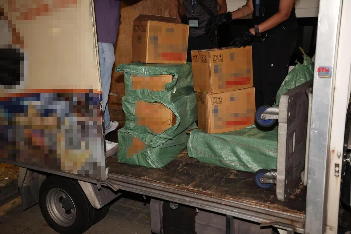 在裕廊西一个组屋露天停车场，关税局人员从一辆罗厘搜出129瓶漏税二锅头酒，一名42岁中国籍男子当场被捕。（邬福梁摄）