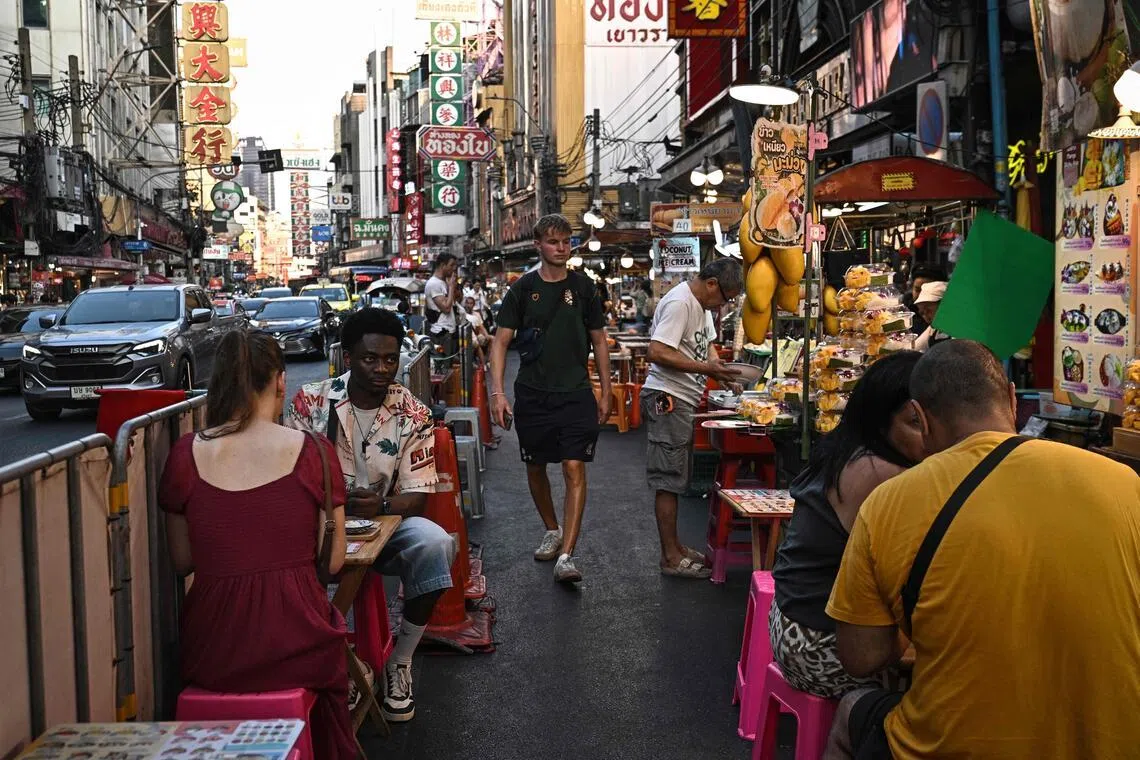 4月29日，游客们正在曼谷唐人街品尝当地街头小吃。唐人街是曼谷繁忙旅游区，街头美食是吸引游客前往的原因之一。（法新社）