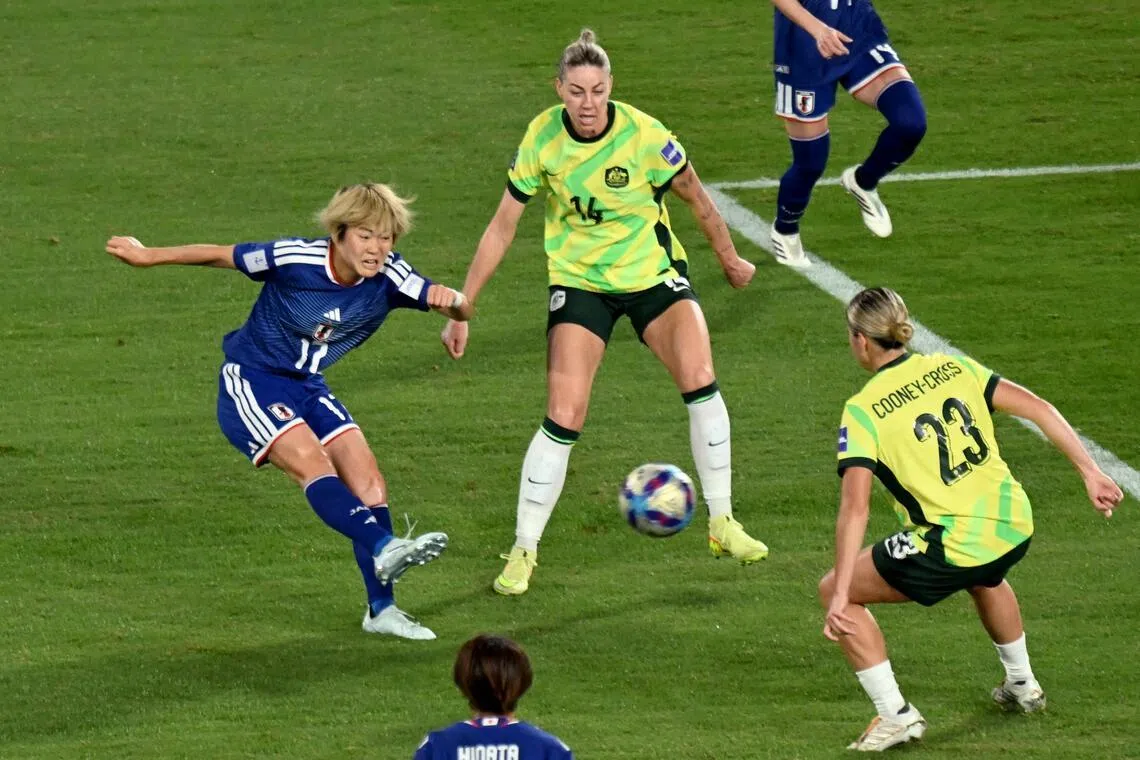 日本前锋滨野舞香（左蓝衣）在禁区外的这脚远射势大力沉，助球队战胜东道主澳大利亚加冕亚洲冠军。（法新社）
