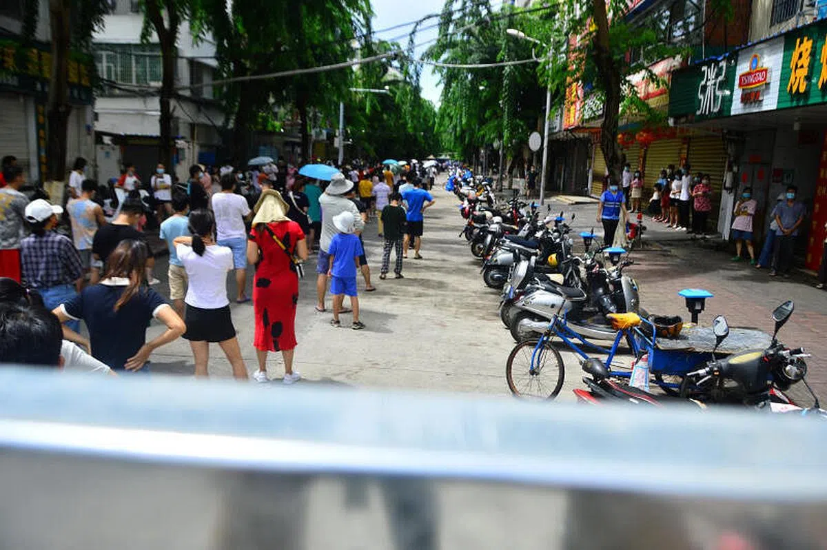 海南三亚市民众8月6日在当地一条街上排队，准备接受核酸检测。（路透社）