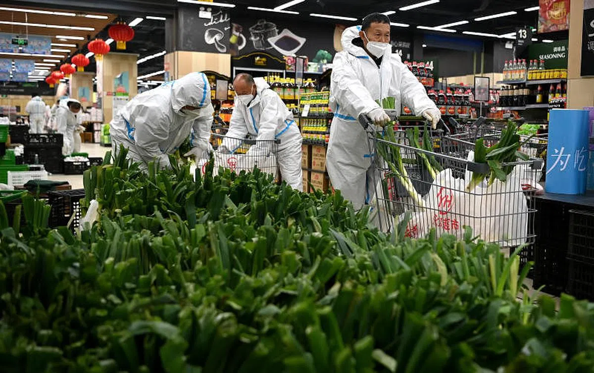 在西安曲江新区一家超市内，超市和疫情防控指挥部工作人员上月28日分装即将配送的免费生活物资。（新华社）