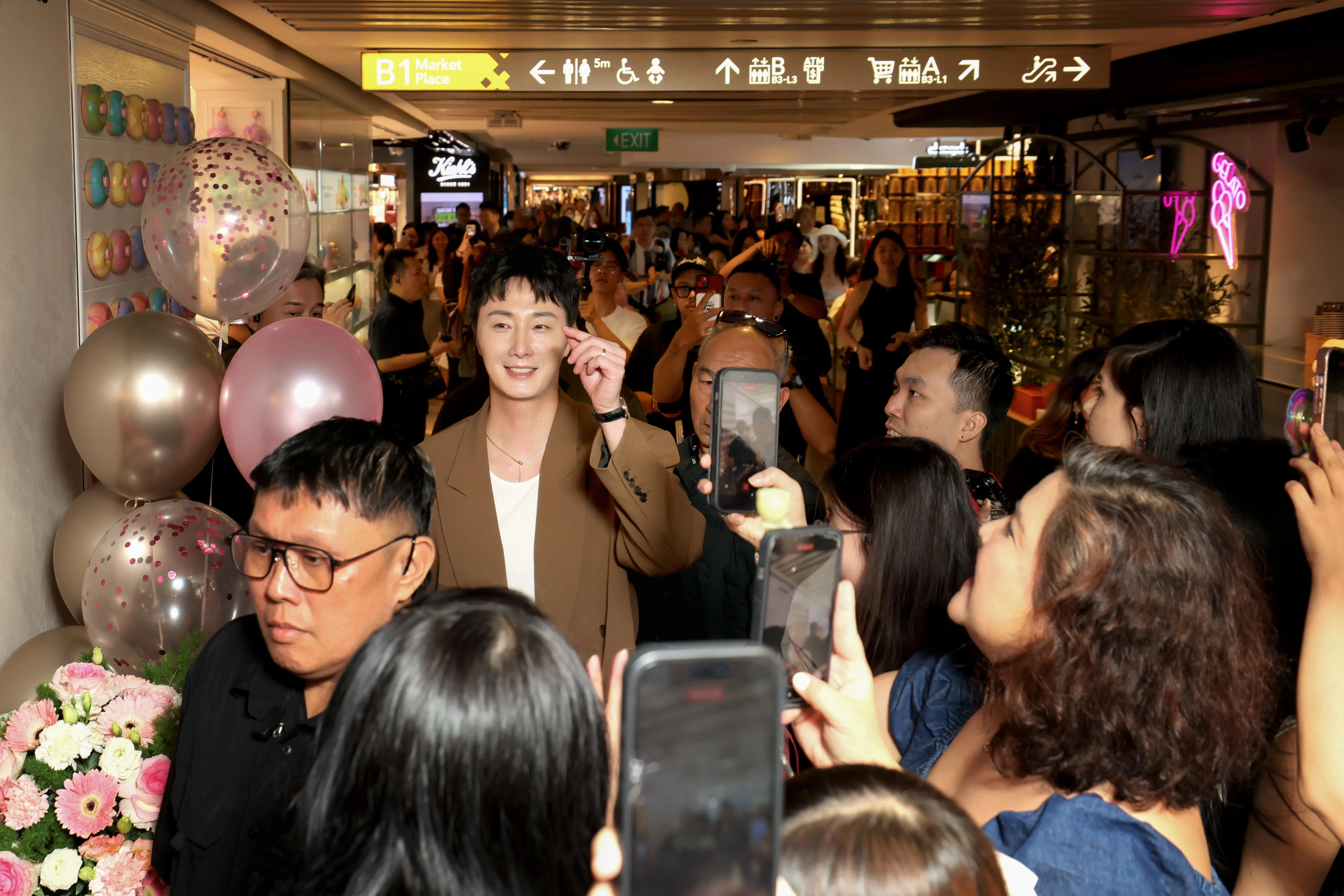 丁一宇身穿卡其色西装，现身护肤品牌盛泰（Seung Tae）位于莱佛士城购物中心的首家旗舰店。（龙国雄摄）