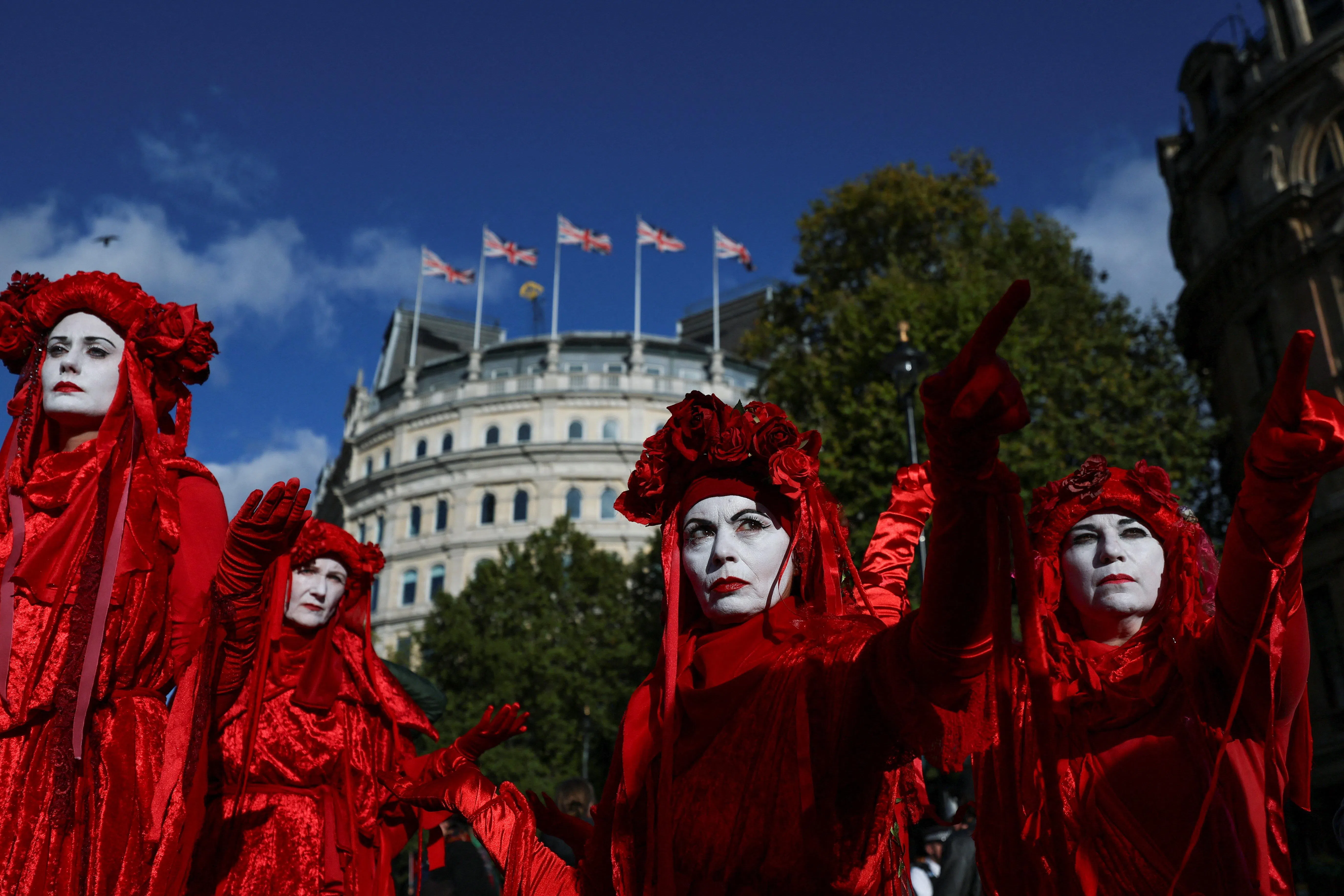 在英国伦敦特拉法加广场，行为艺术团体“红色叛军旅”（Red Rebel Brigade）的成员身穿红色服饰参与支持巴勒斯坦的抗议游行，以纪念加沙战争三周年。（路透社）