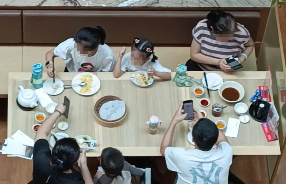 警报响起的瞬间，不少用餐的公众下意识地查看手机。（读者提供）