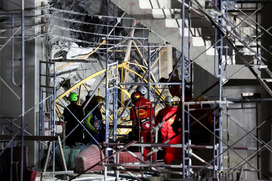 3月28日，救援人员在曼谷一处建筑物倒塌现场搜寻伤亡人员。（路透社）
