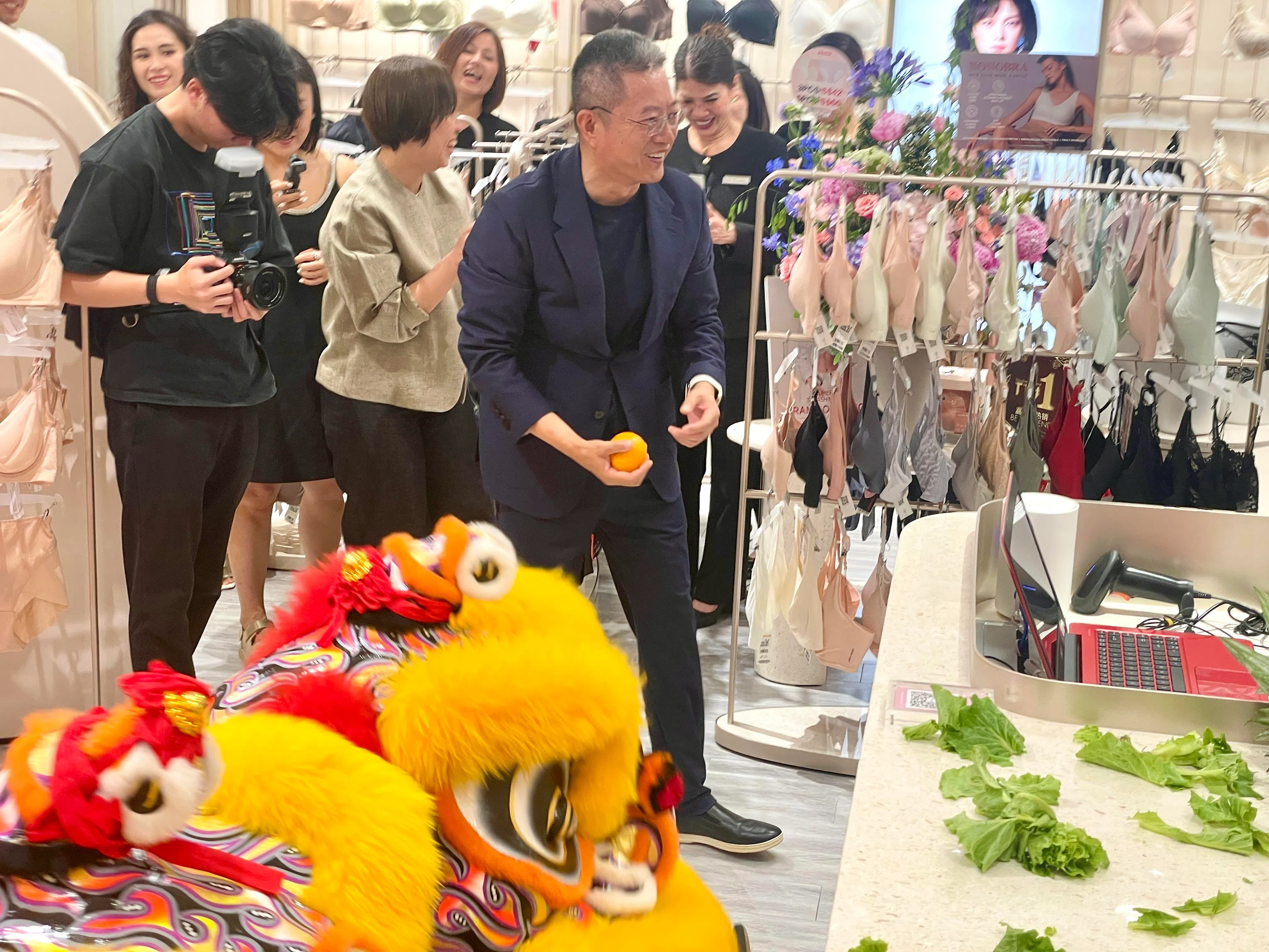 爱慕创始人兼总监张荣明在舞狮开幕环节开心地参与采青，为新店引入好彩头。（林方伟摄）