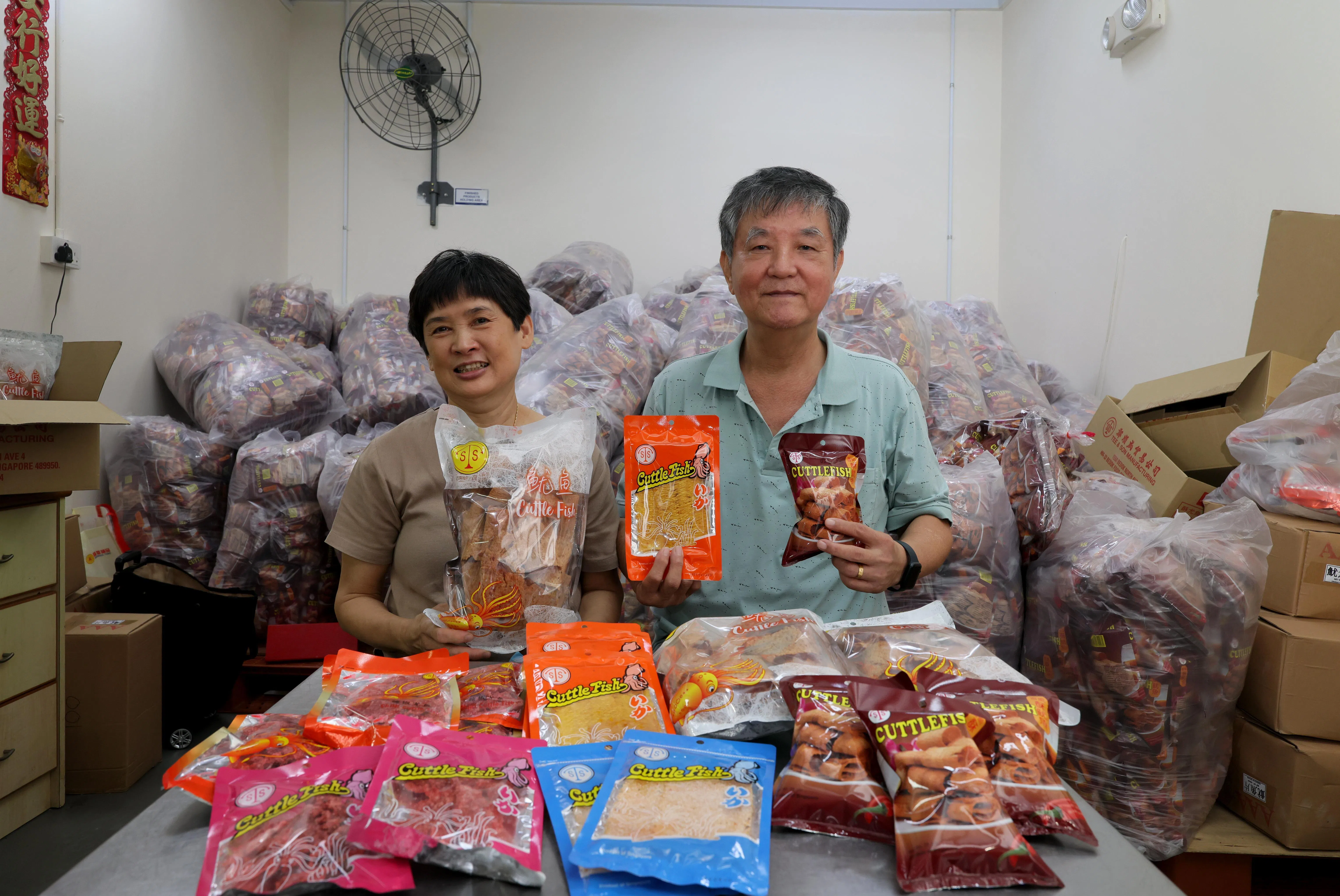 郑仲珉夫妇对所生产的烤鱿鱼品质和口味具信心。（龙国雄摄）