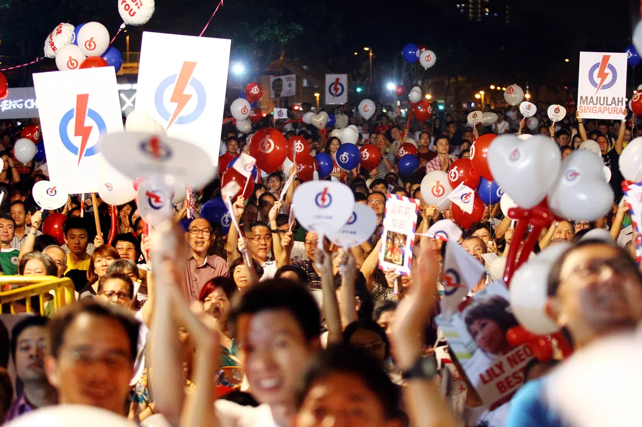 2015年大选，人民行动党惹兰勿刹集选区竞选团队9月9日在文庆路第4座组屋前草场举行选举群众大会。行动党支持者拿着扇子和气球为候选人打气。（档案照片）