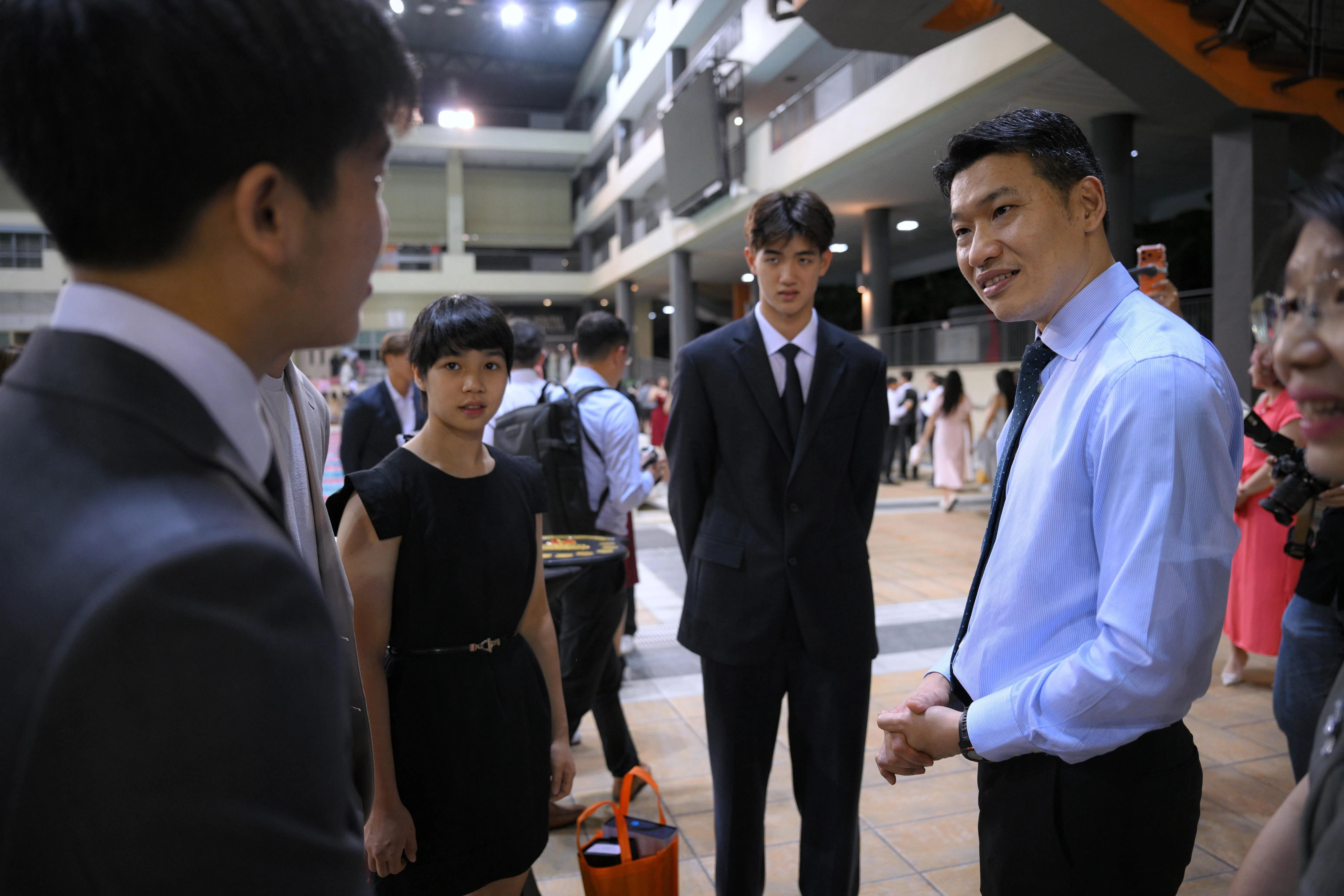 文化、社区及青年部代部长兼教育部高级政务部长梁振伟（蓝衣）到场为运动员们颁奖，并与年度杰出学生运动员奖得主交谈。（海峡时报）
