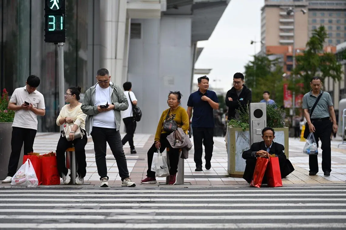 学者认为，四中全会强调推动质量发展，意味着中国将更多关注人民满意程度。图为9月15日北京街头的行人。（法新社）