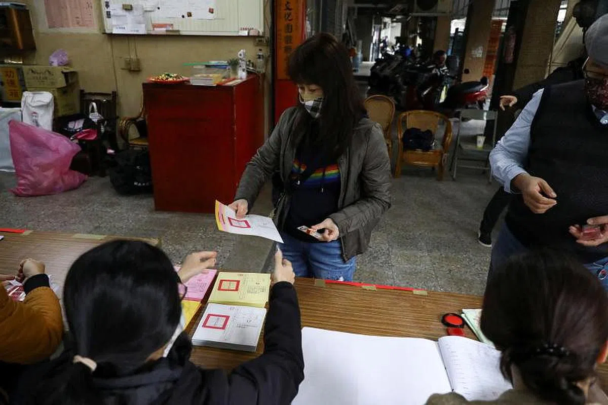 新北市一名女子今天在在投票站领取四项公投选票。（路透社） 
