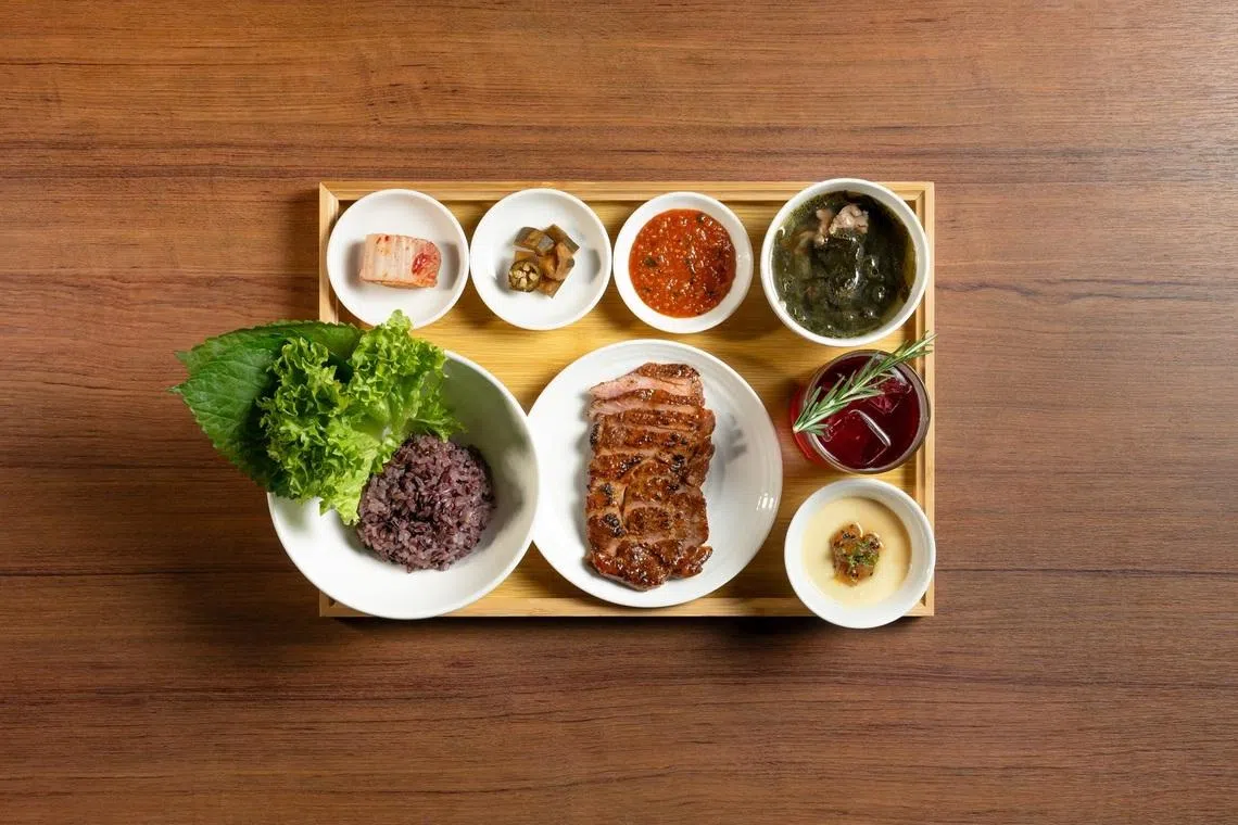 猪颈饭套餐，饭香肉嫩，搭配开胃小菜、汤品和蒸蛋。（餐馆提供）