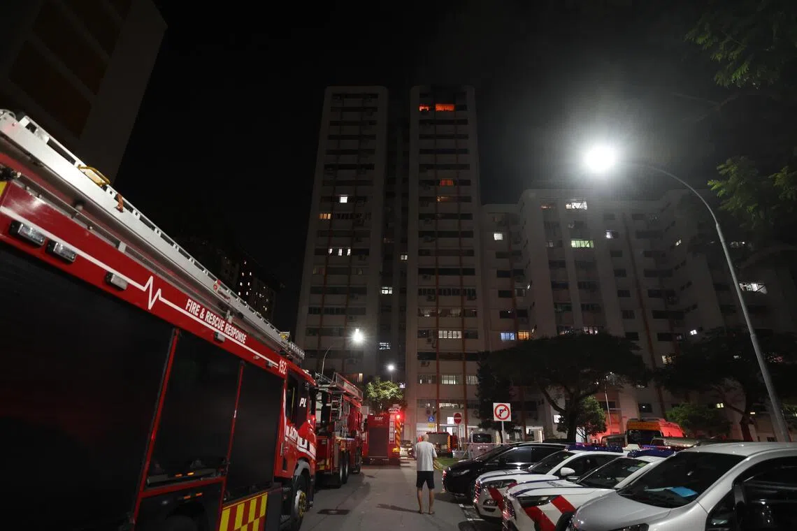 事发单位火光熊熊，组屋楼下站了不少围观公众，现场来了至少三辆消防车。（梁麒麟摄）