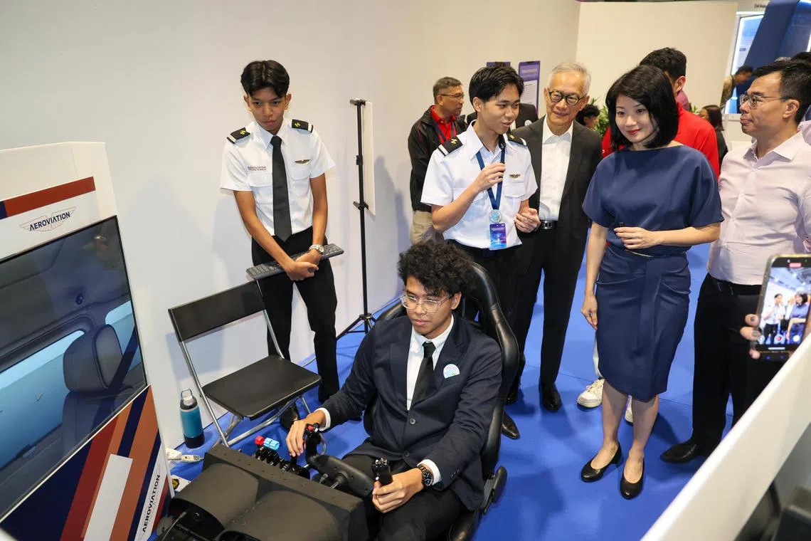 职业展有超过40家航空公司、教育机构与合作伙伴参展，提供1500多个职位空缺，并安排现场面试。公众可体验飞行模拟器（图）、无人机足球等活动。右二是交通部兼国家发展部高级政务部长孙雪玲。（张俊杰摄）