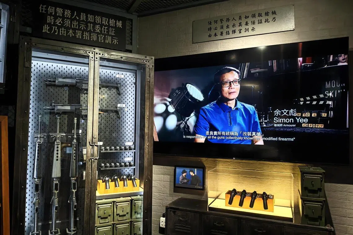 枪房内陈列着各式惟妙惟肖的道具枪械，墙上屏幕同步播放枪械师分享经验与幕后故事的短片。（陈爱薇摄）