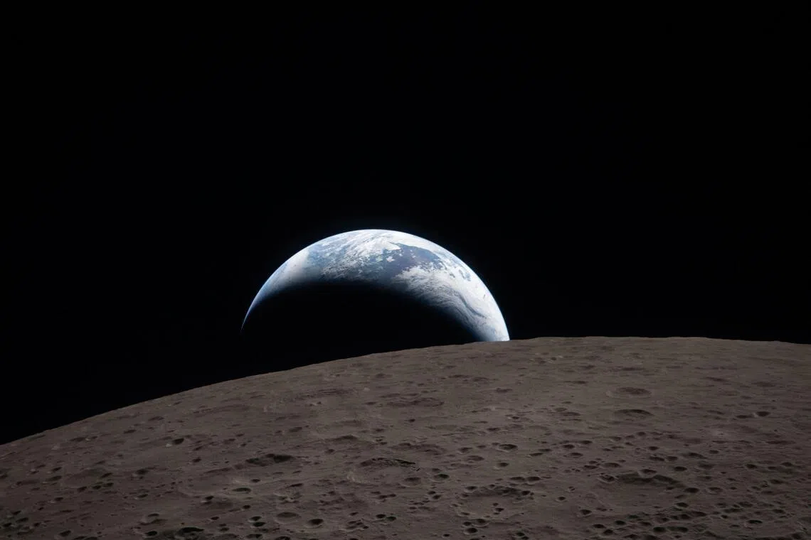 NASA发布猎户座飞船于4月6日拍摄的照片显示，地球在月球地平线下缓缓落下的过程，也称为“地落”（Earthset）。（法新社）