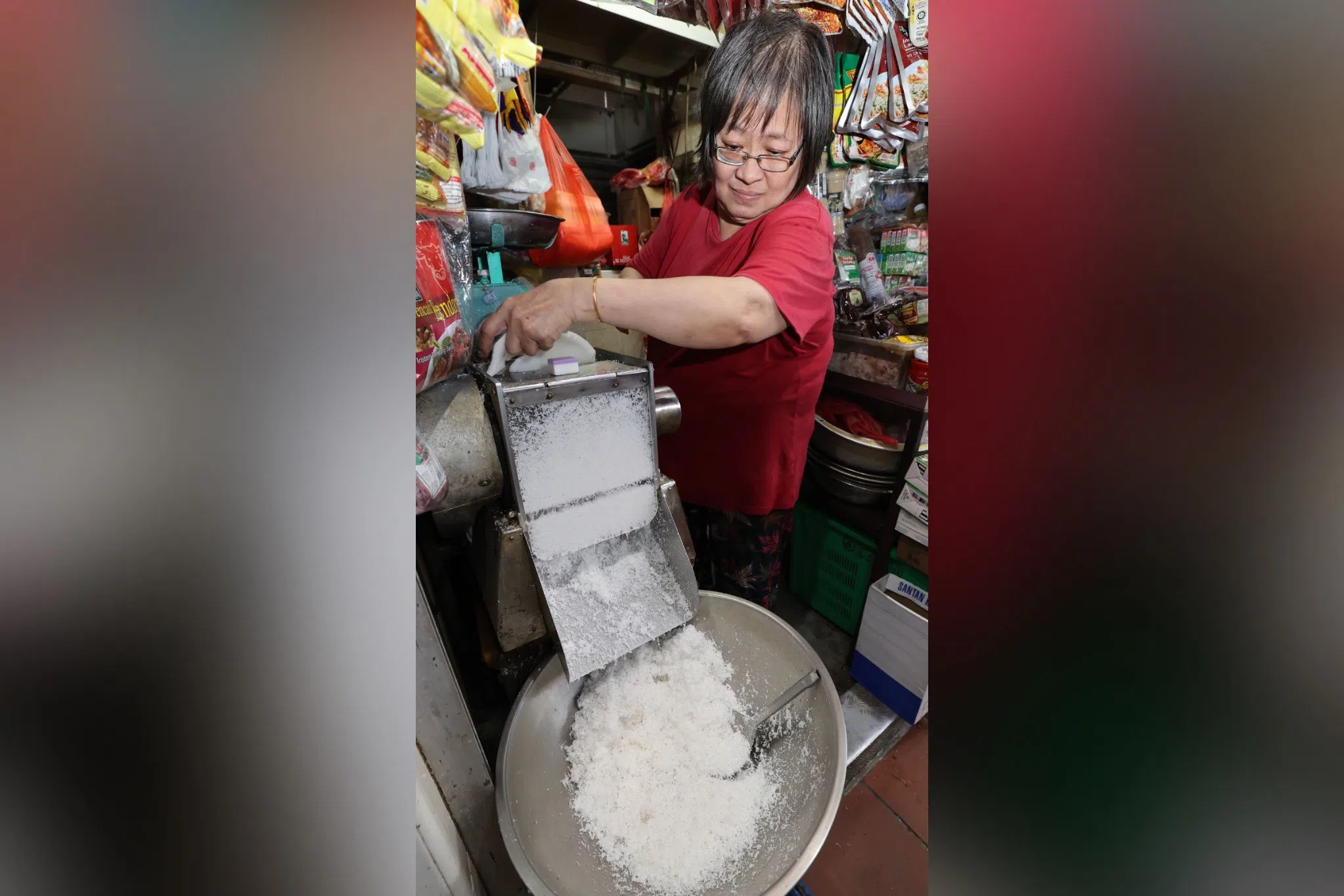 在竹脚中心售卖新鲜椰丝的摊贩谢来凤说，近几个月来自马来西亚的椰子成本价上涨，整体涨幅至少三成。（邬福梁摄）