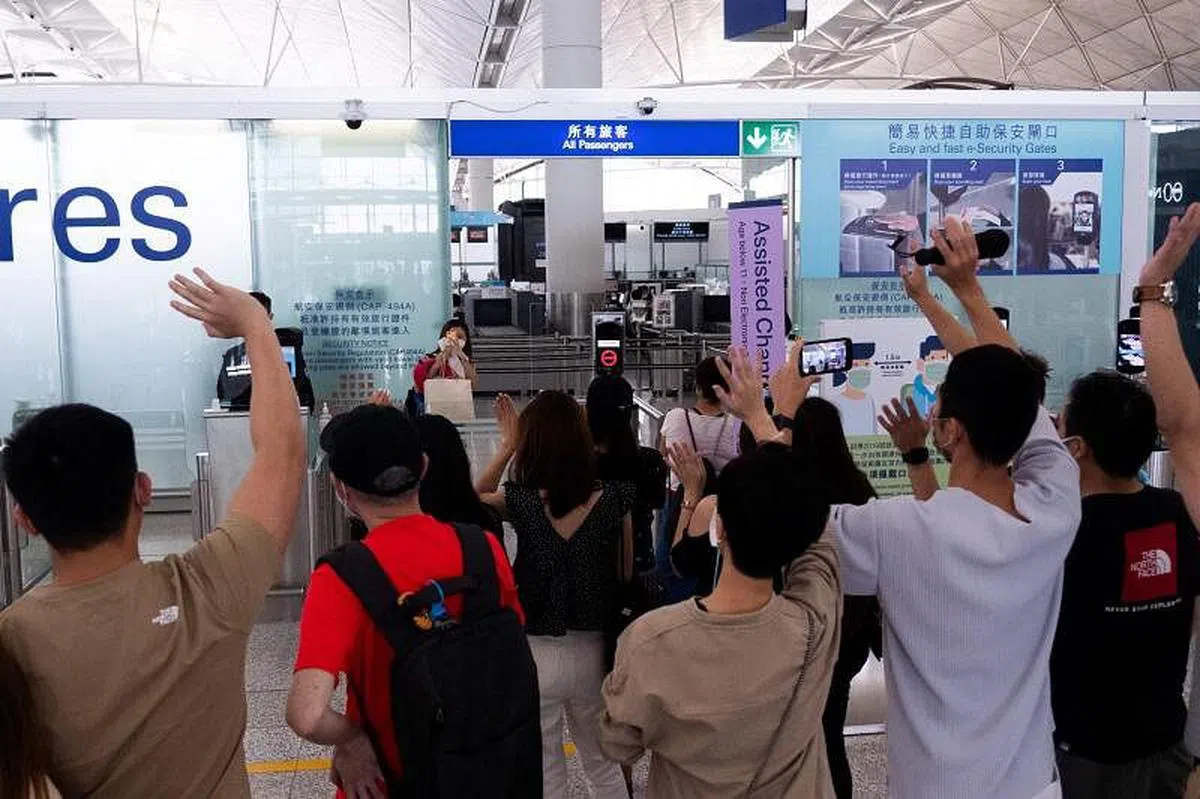 很多民众昨天到机场送别亲友。图为一名女子为向她挥手告别的朋友拍照。（法新社） 