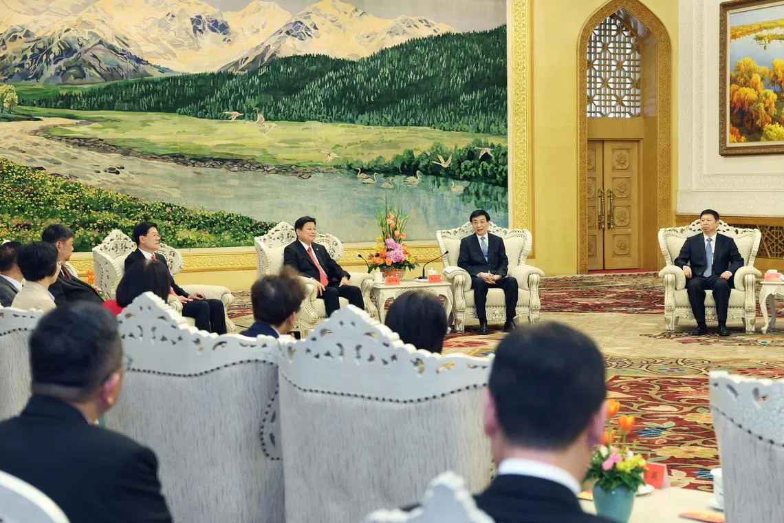 王沪宁（右二）4月27日在北京与傅崐萁（右三）会面后，大陆官方随后宣布，重启福建居民到马祖观光、北京和上海等20个城市可在网上申办补发赴台“入台证”，并恢复开放台湾文旦柚进口等。图为王沪宁与傅崐萁一行在人民大会堂新疆厅会面。（新华社）