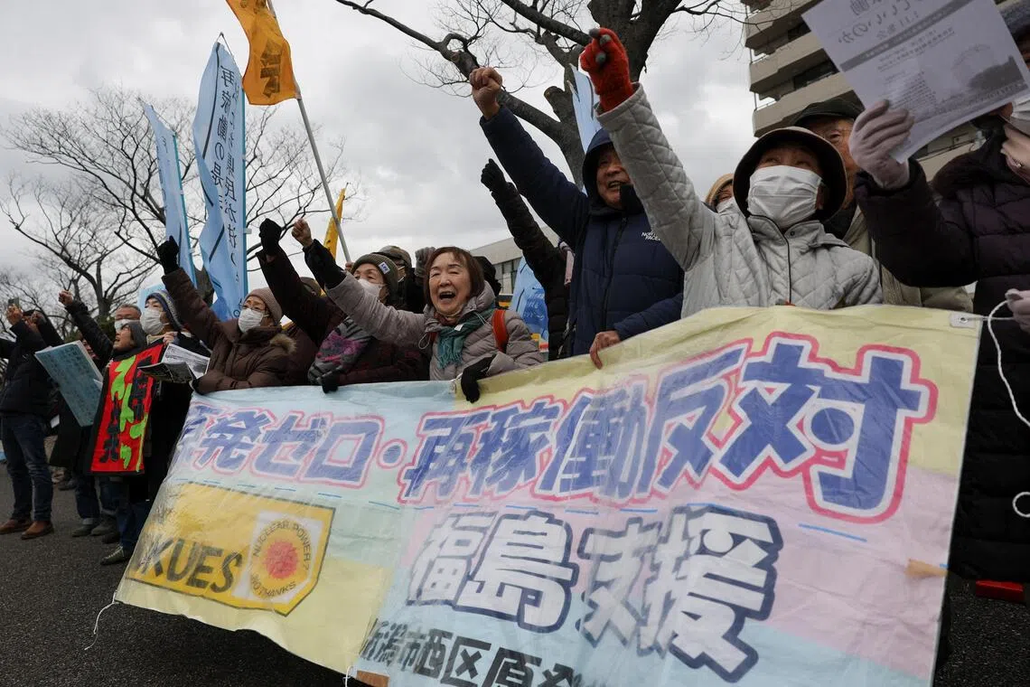 在新潟县议会投票前，抗议者在县政府办公楼前举行集会，举着写有“反对核能”、“反对重启柏崎刈羽核电站”和“支持福岛”的横幅。（路透社）