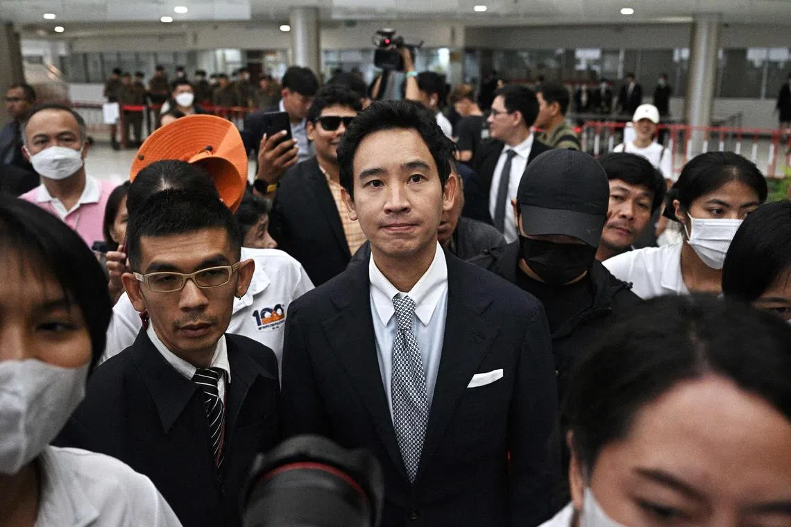 泰国前进党前党魁披塔（中）于8月7日代表党出庭聆听宪法法院的裁决。他之后在党总部的记者会上安抚失望及愤怒的支持者，并希望支持者能将怒气化为选票来表达不满。（法新社）