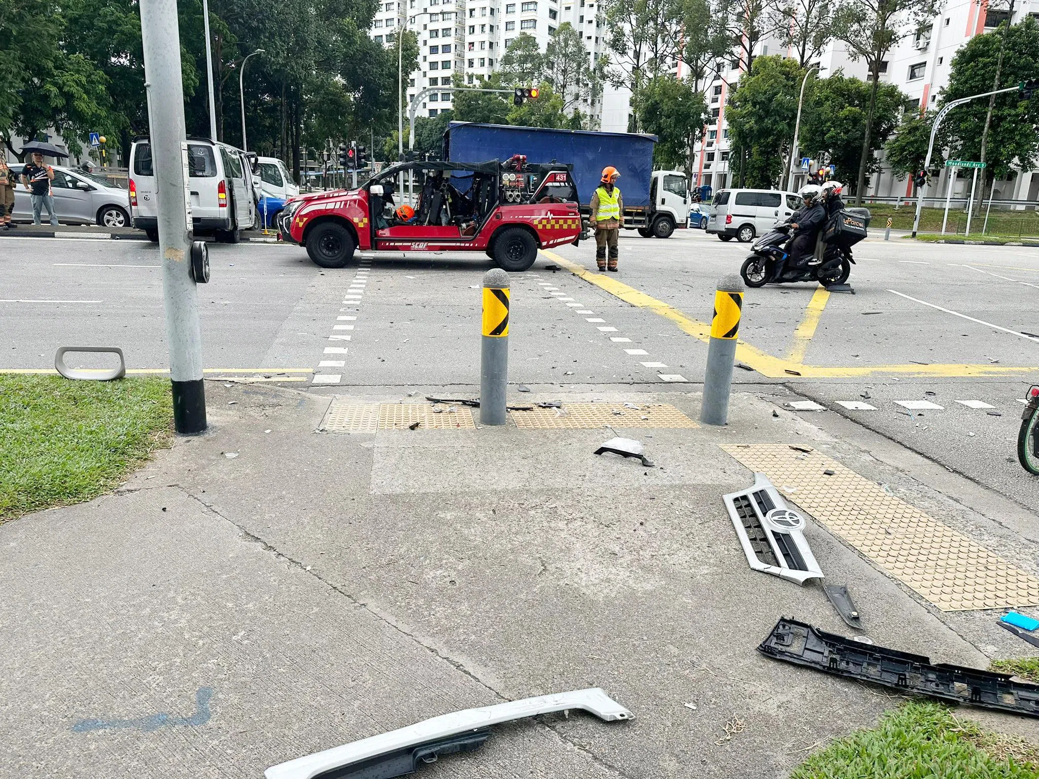 猛烈撞击力导致一些汽车零件落在人行道上。（读者提供）