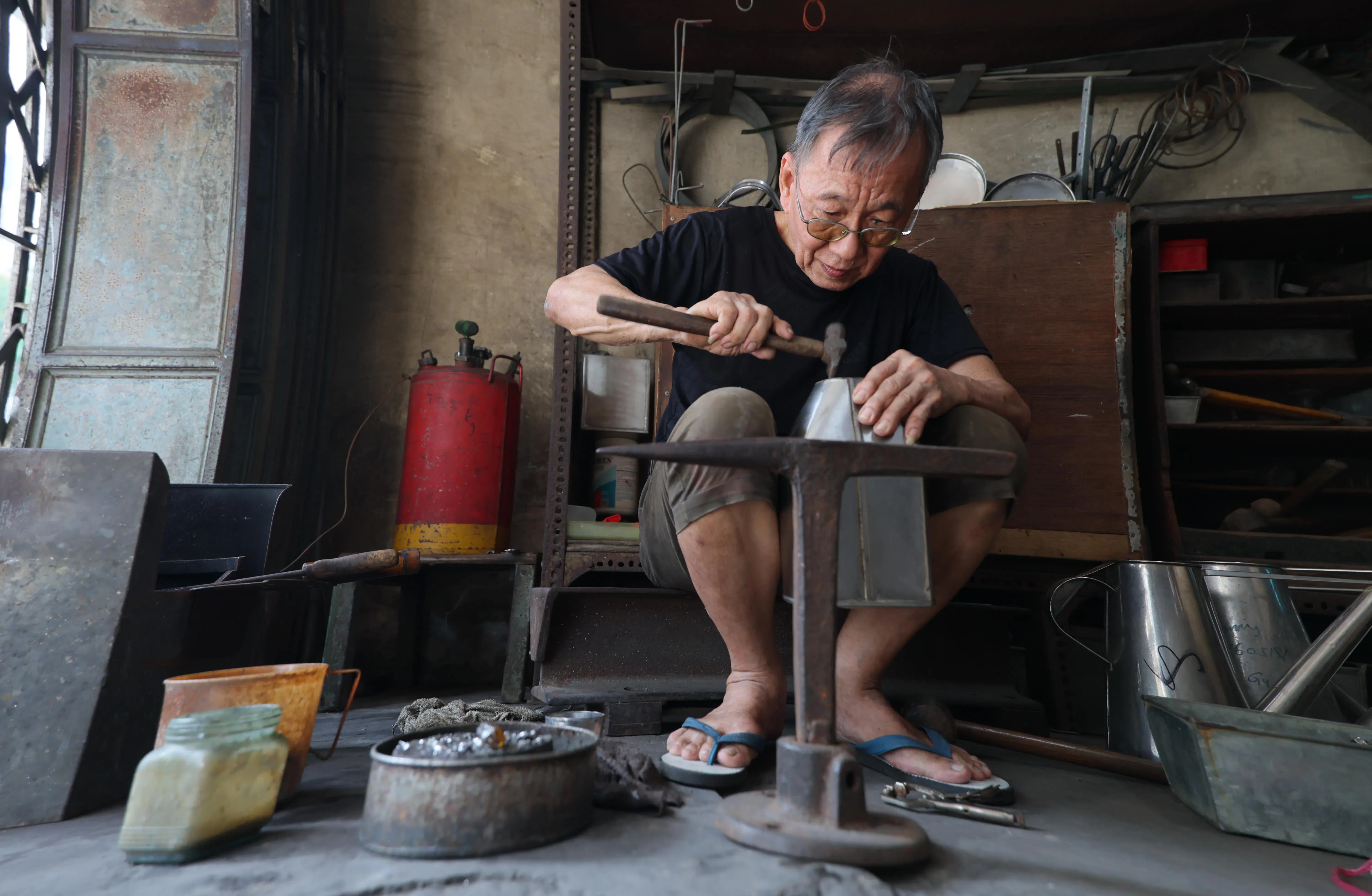除了制作工业用途的定制白铁件，陈金福也替顾客修补传统咖啡壶等器具。（龙国雄摄）
