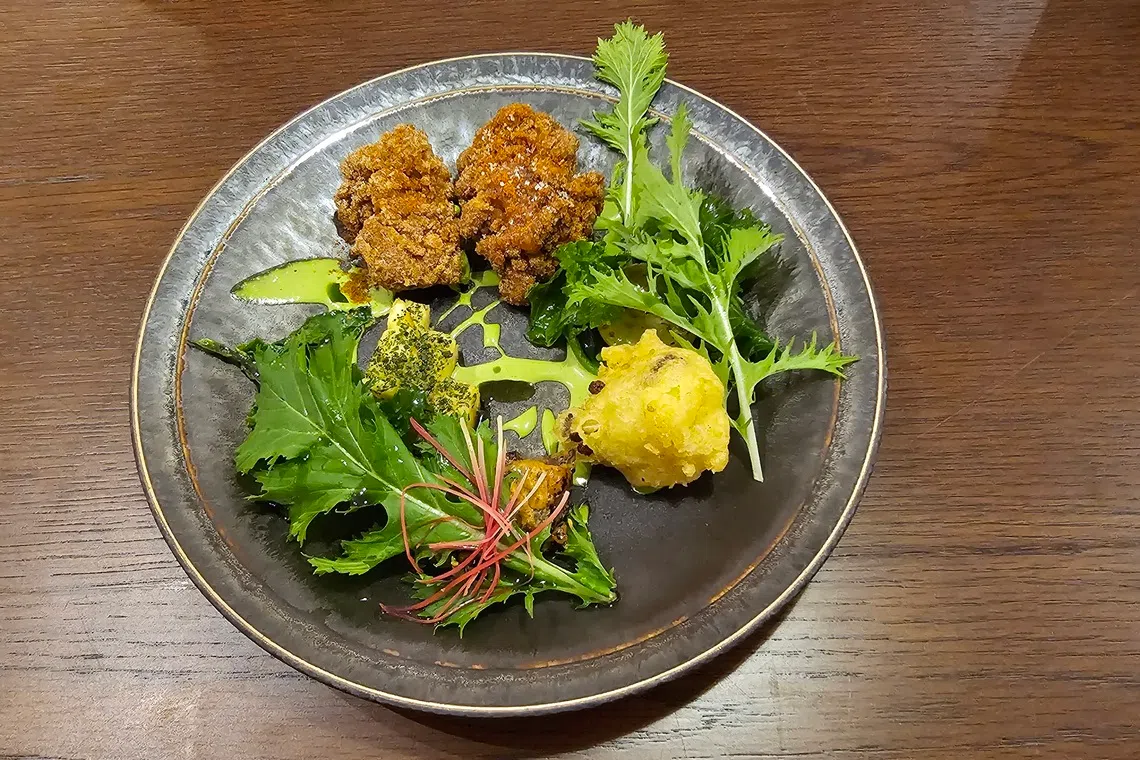 这道印度罗惹以和牛豆皮寿司卷等炸物为主，搭配蔬菜及姜花，口感味道有层次。（黄亿敏摄）