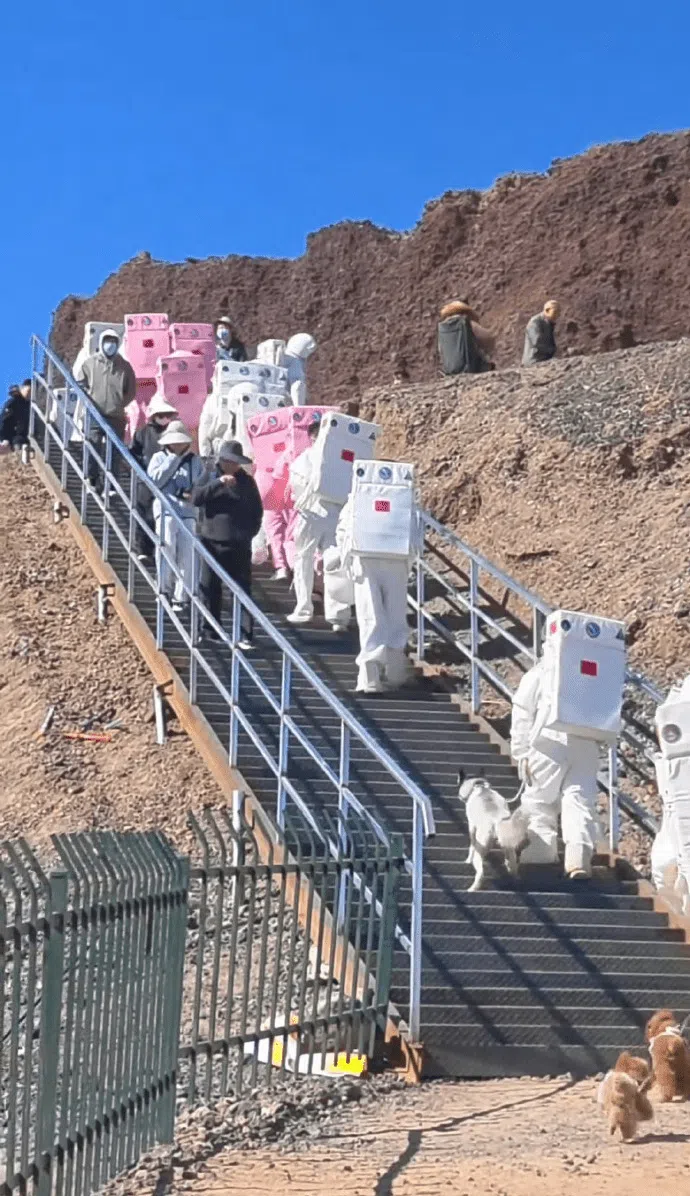 身穿白色或粉色宇航服的游客排队等候登上乌兰哈达火山口。（互联网）