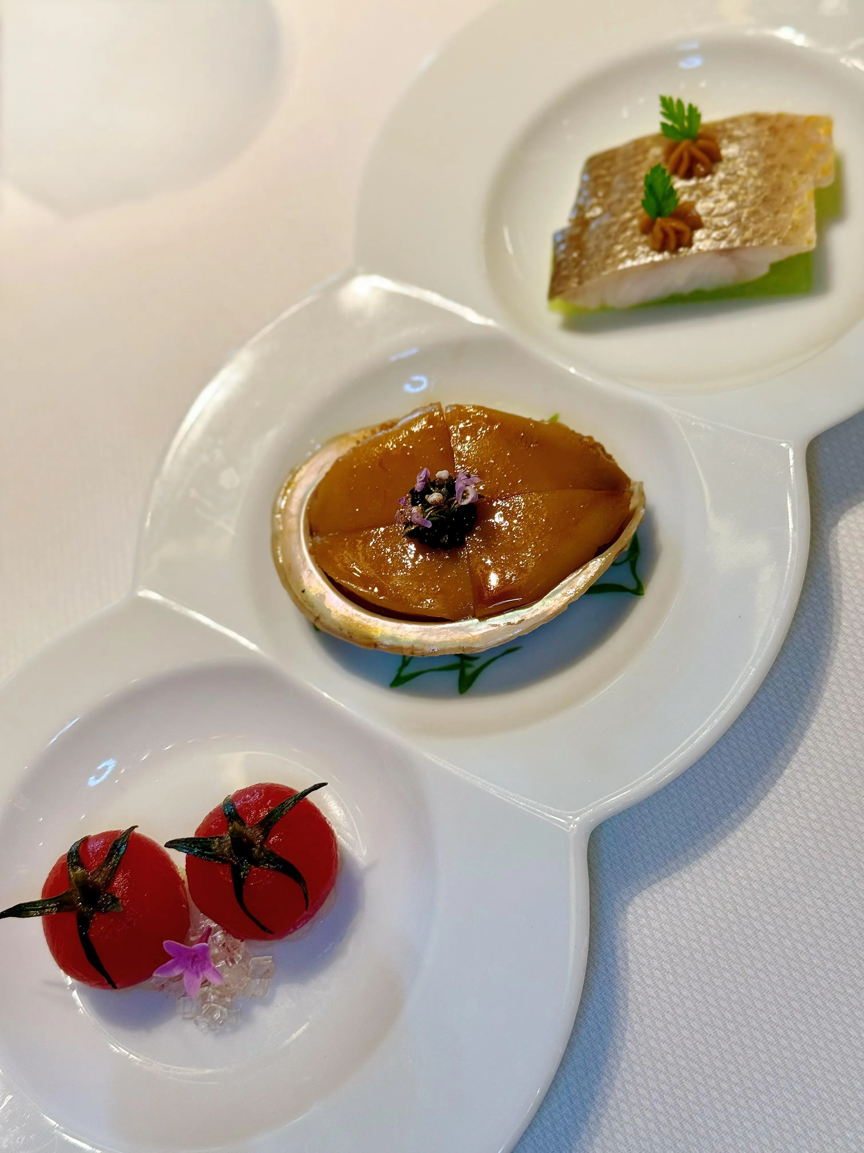 厨师拼盘包括三款前菜：冰梅温室小番茄（左起）、椒麻捞汁鲍鱼，以及潮式冻黄鱼饭。（叶晓虹摄）