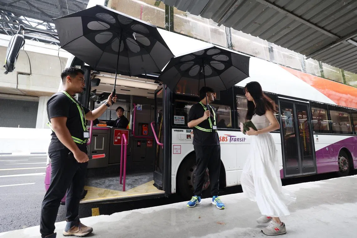 丹那美拉站星期一上午约8时30分下起绵绵细雨，工作人员暖心为乘客撑伞。（郑一鸣摄）