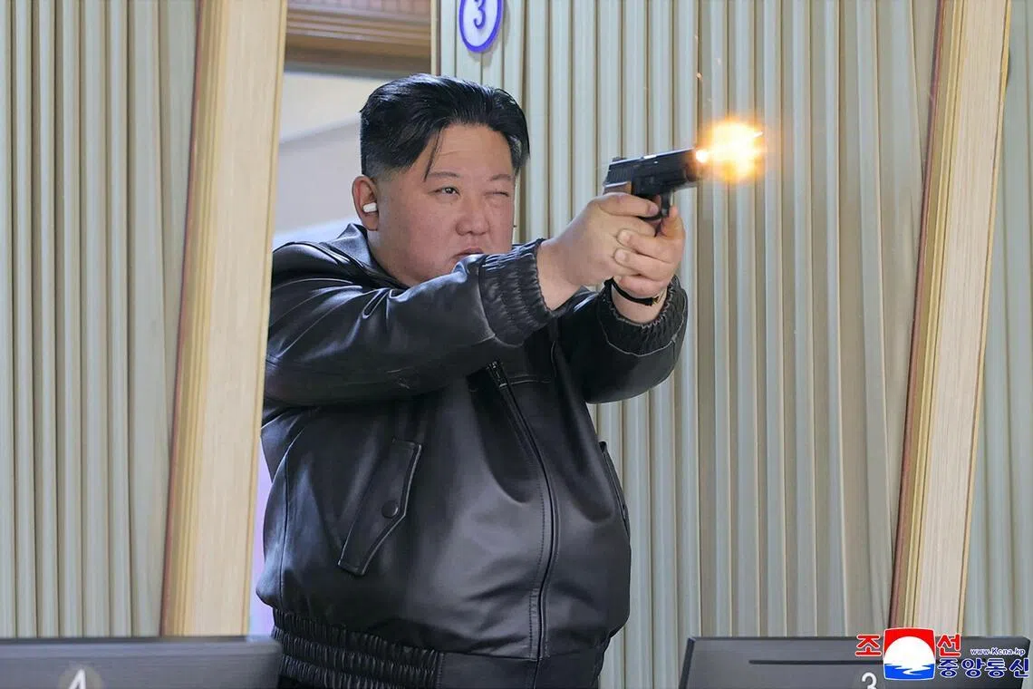据朝中社发布的照片，身穿黑色皮夹克的金正恩周三在一家军需工厂的射击场试射新型手枪。（法新社）