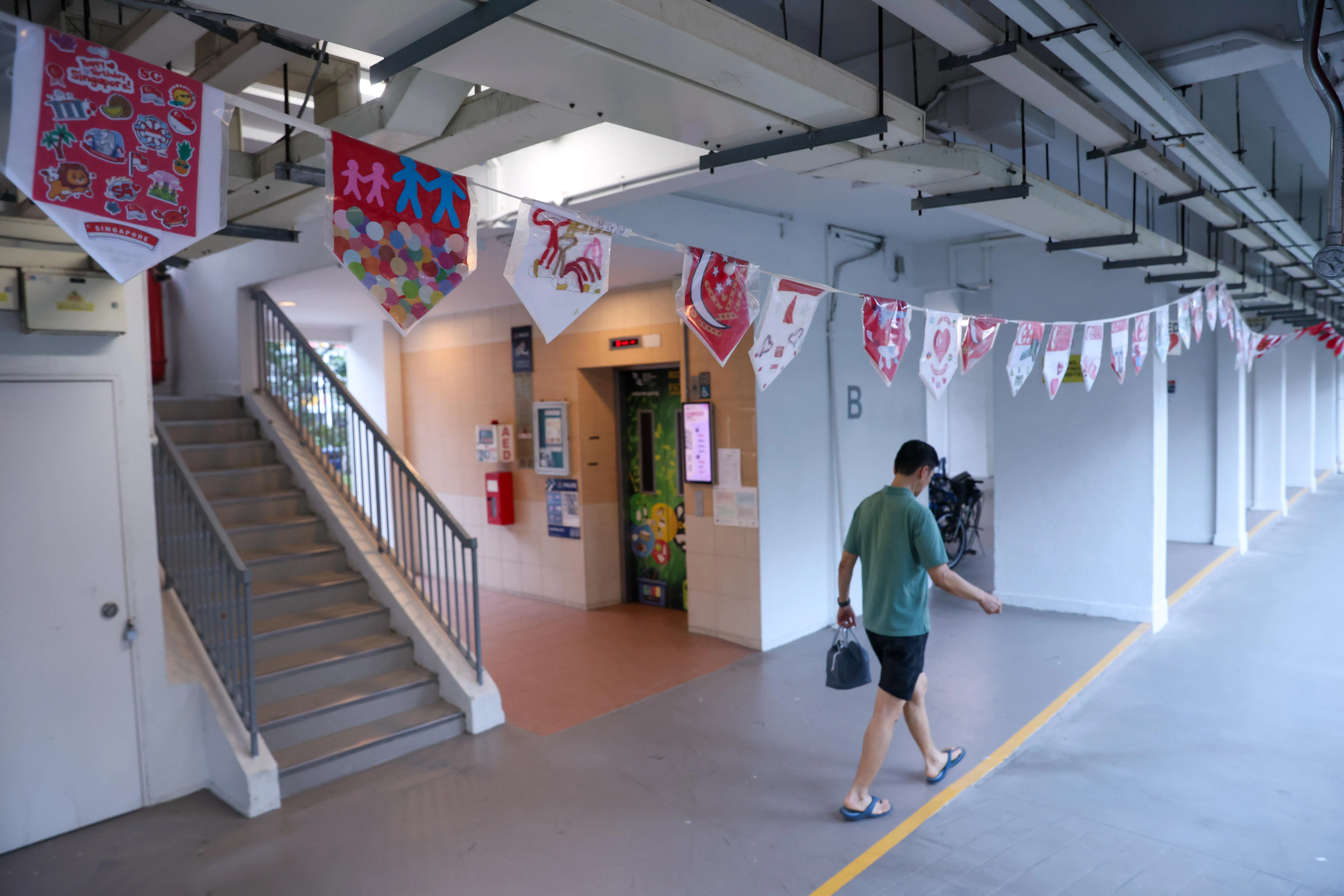 彩旗目前横跨淡滨尼5道的第147、第148和第149座组屋底层。国庆日后，伊斯万迪打算把旗帜拼成“壁画”，继续展示在组屋底层。（白艳琳摄）